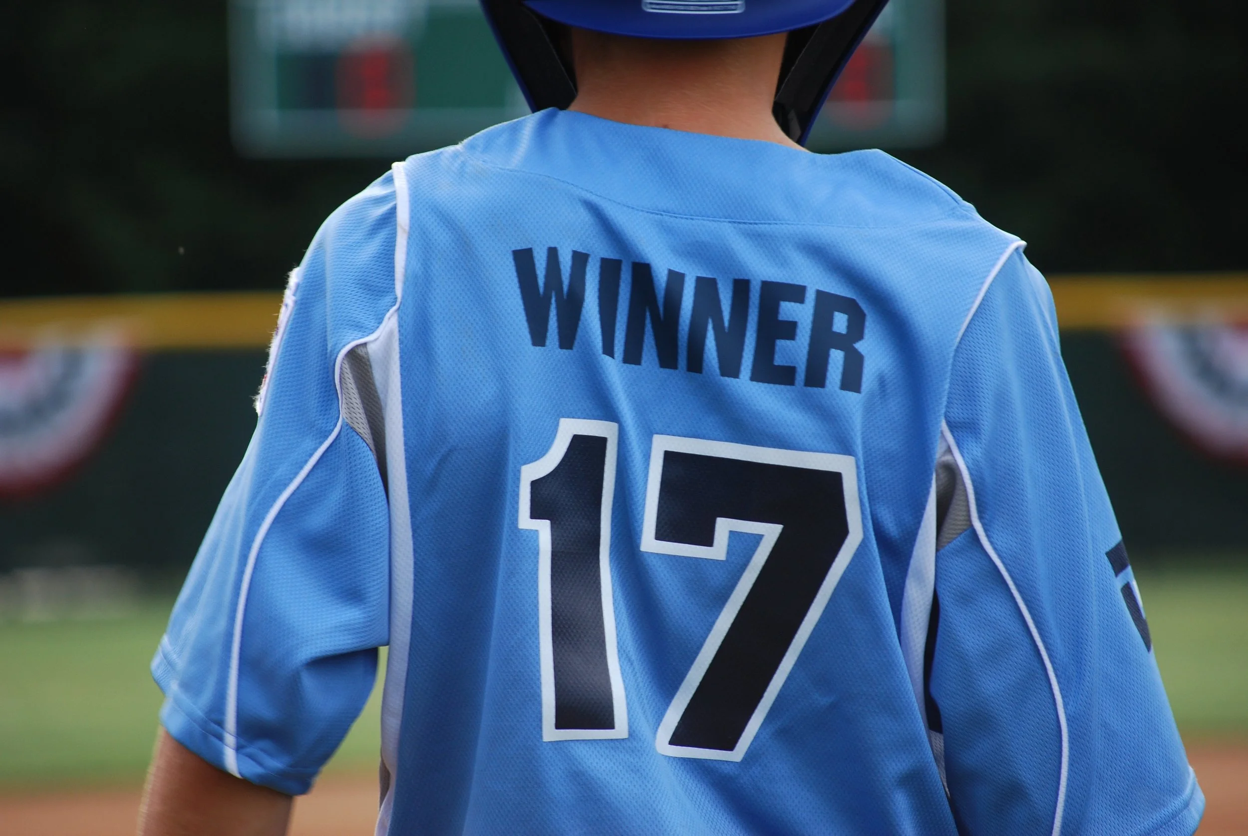 Child wearing Blue baseball jersey with Winner