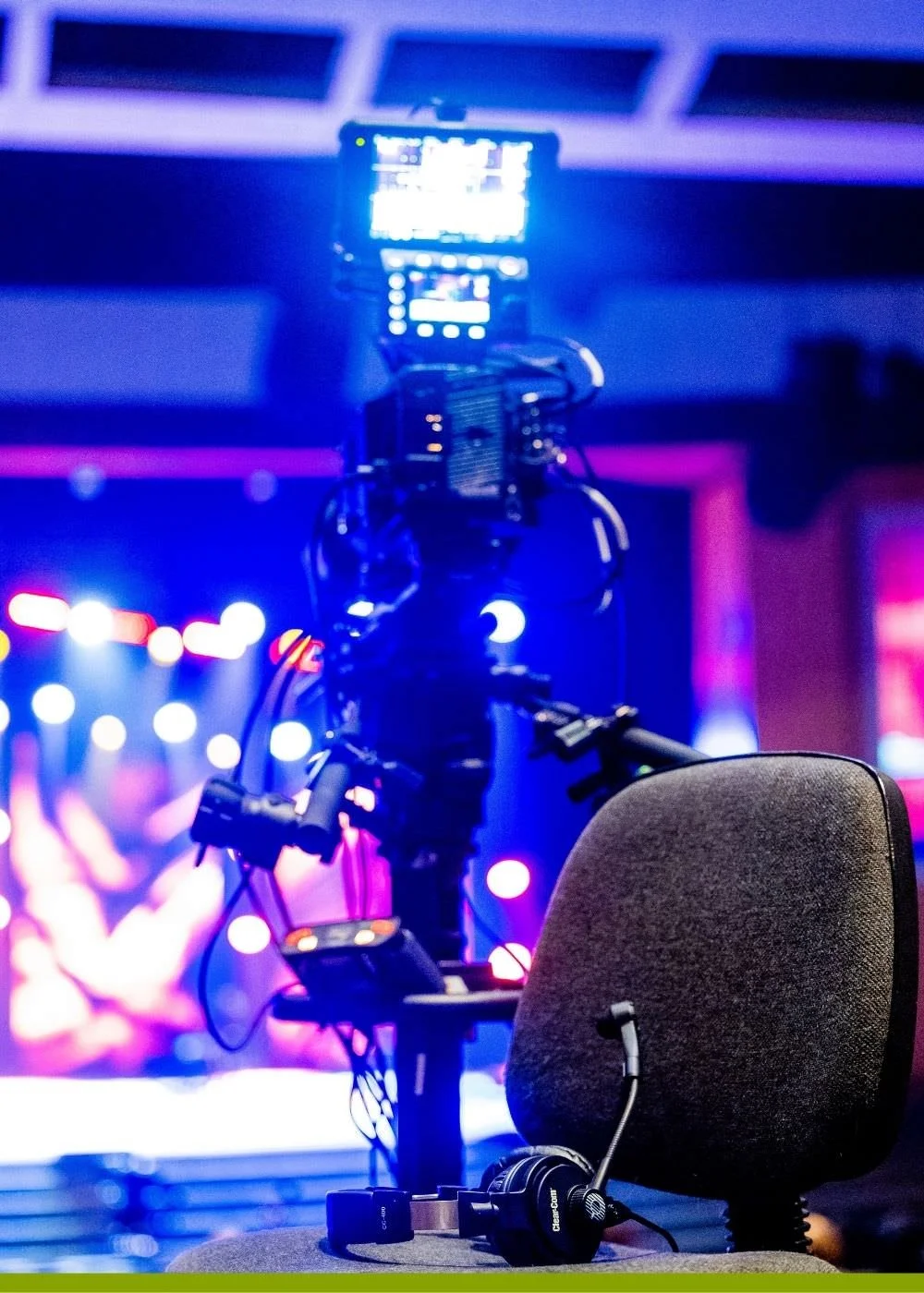 A picture of a film camera and chair surrounded by blue and pink light.