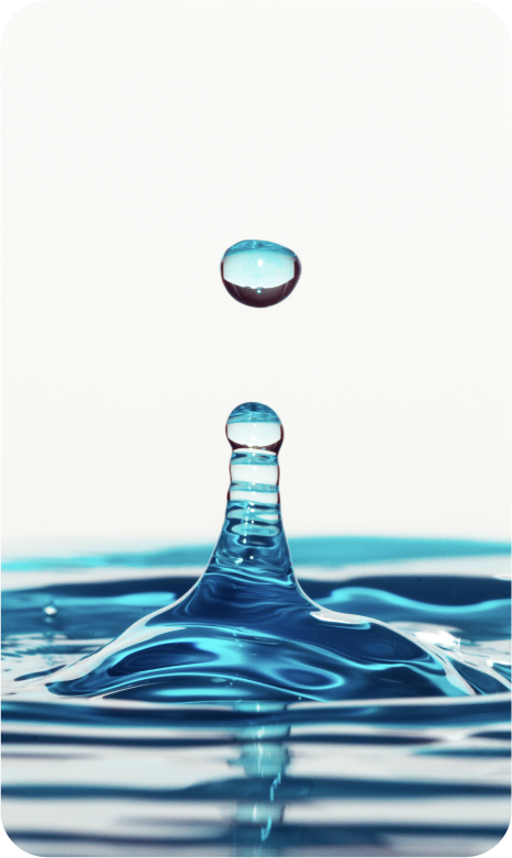 Close-up of a water droplet splash with a single droplet falling into water, creating a ripple effect