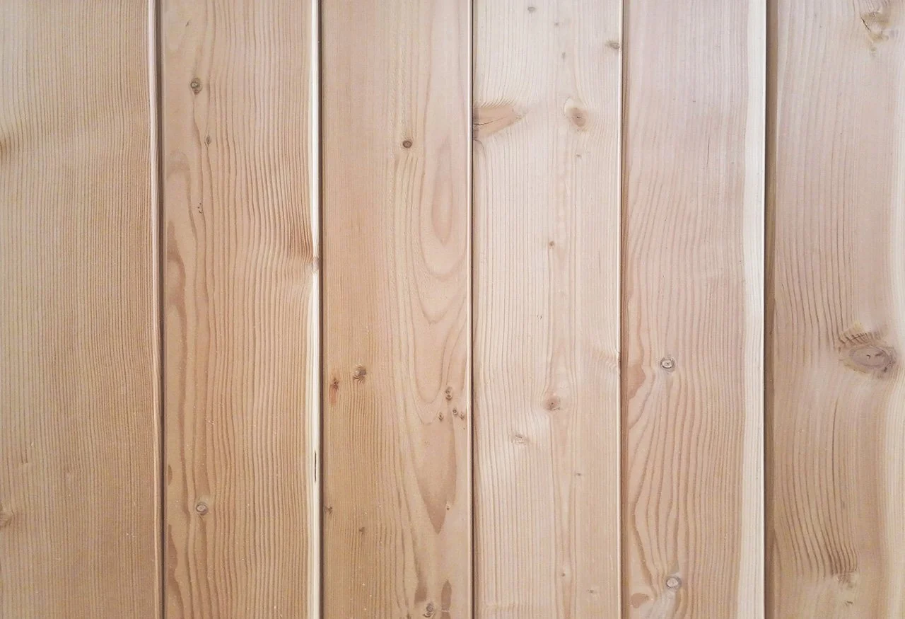Close-up of wooden paneling with vertical planks and visible wood grain.
