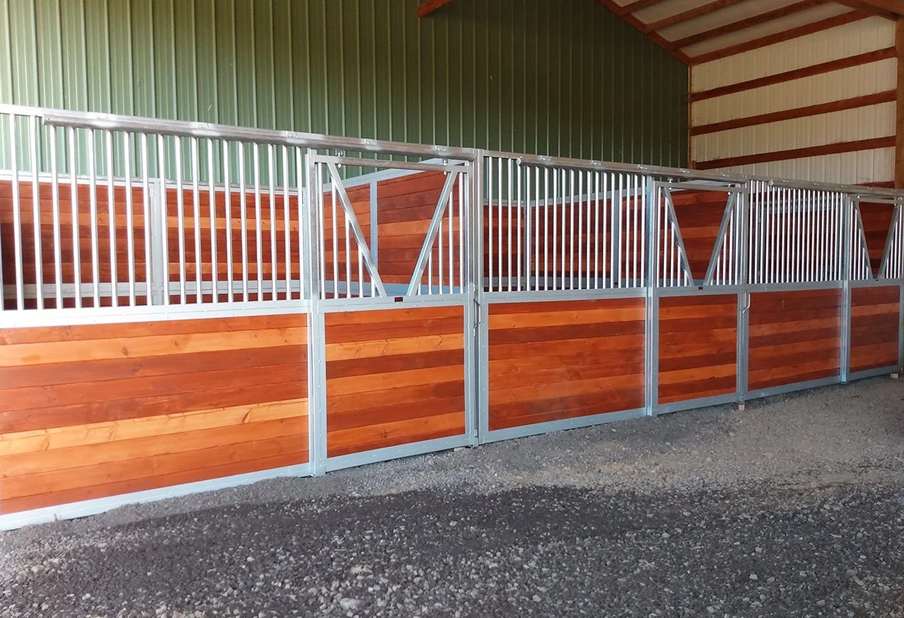Stall boxes with wooden panels and metal bars at a stable.