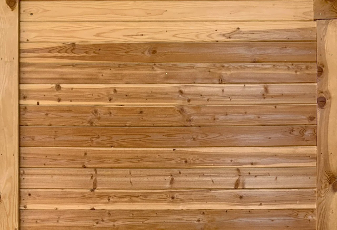 Close-up of a wooden wall with horizontal planks and a natural wood finish.