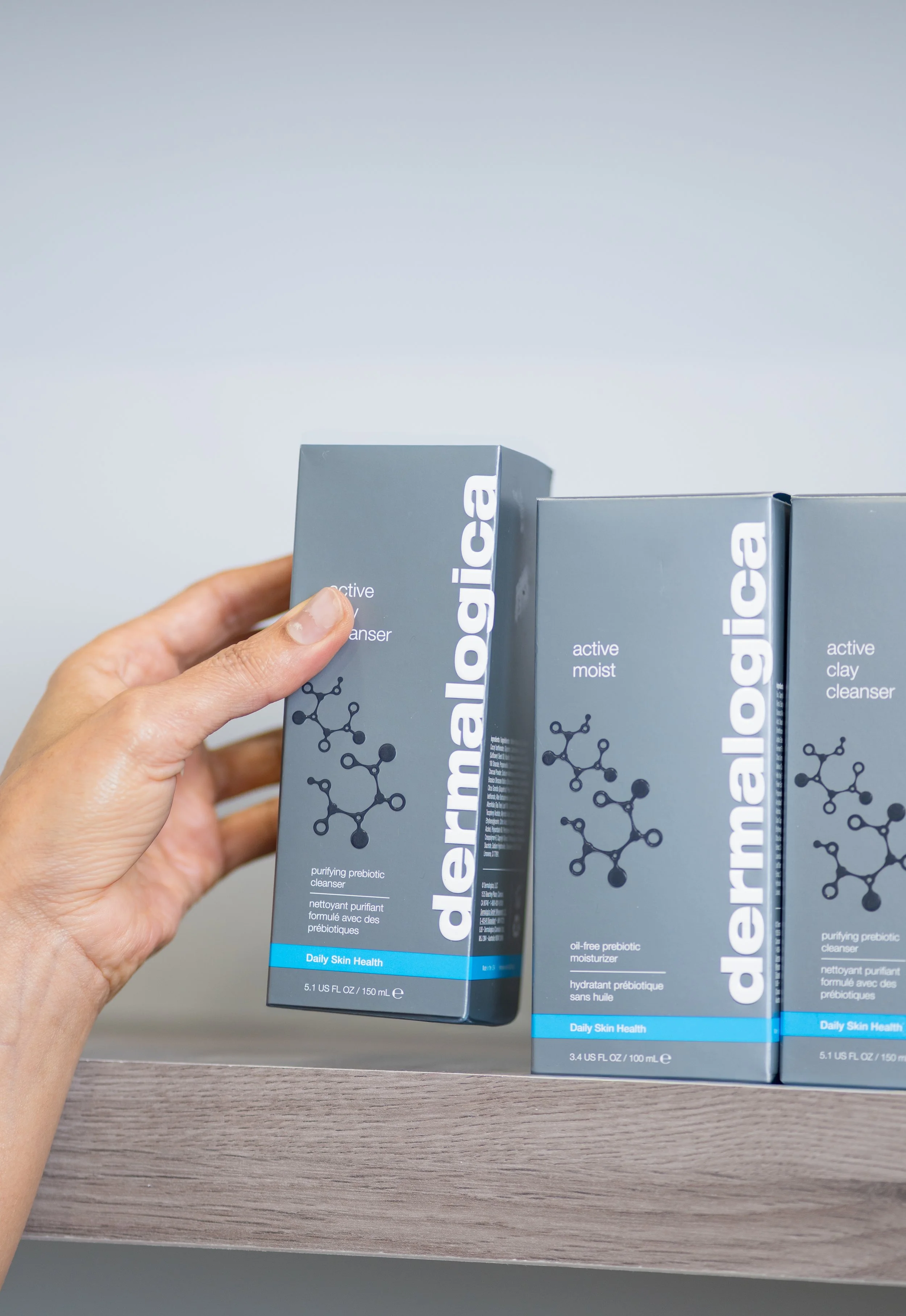 A close up branding photo shot of a hand holding a box of Dermalogica inside a Calgary spa.