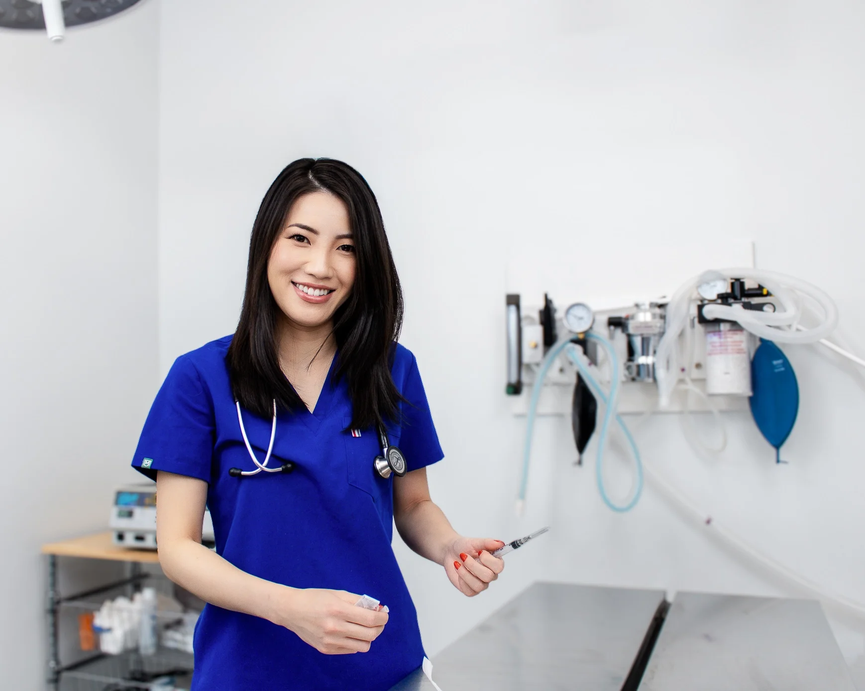 A smiling female vet posing in a medical room for a headshot and branding photos in Calgary. 