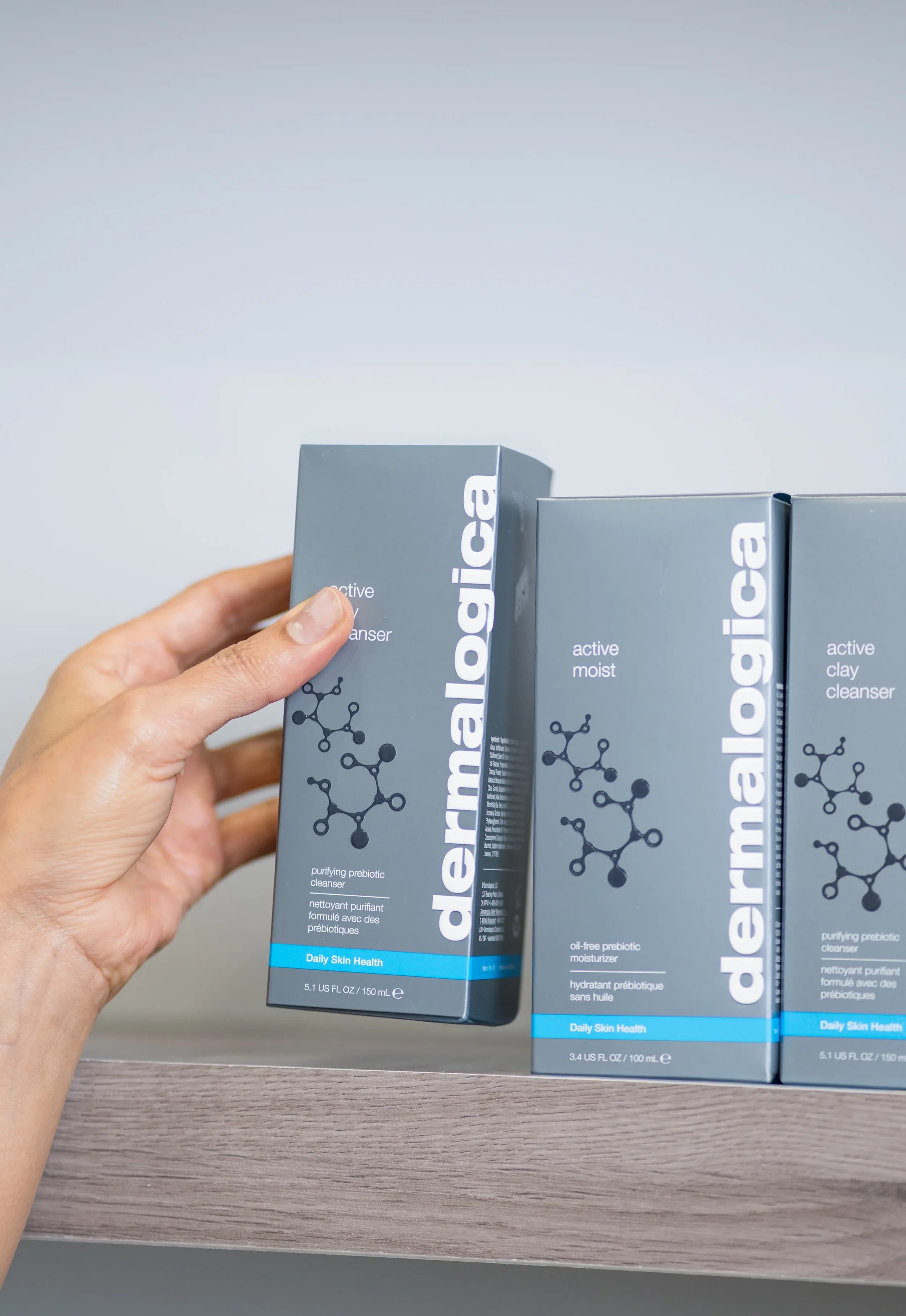 A close up branding photo shot of a hand holding a box of Dermalogica inside a Calgary spa.