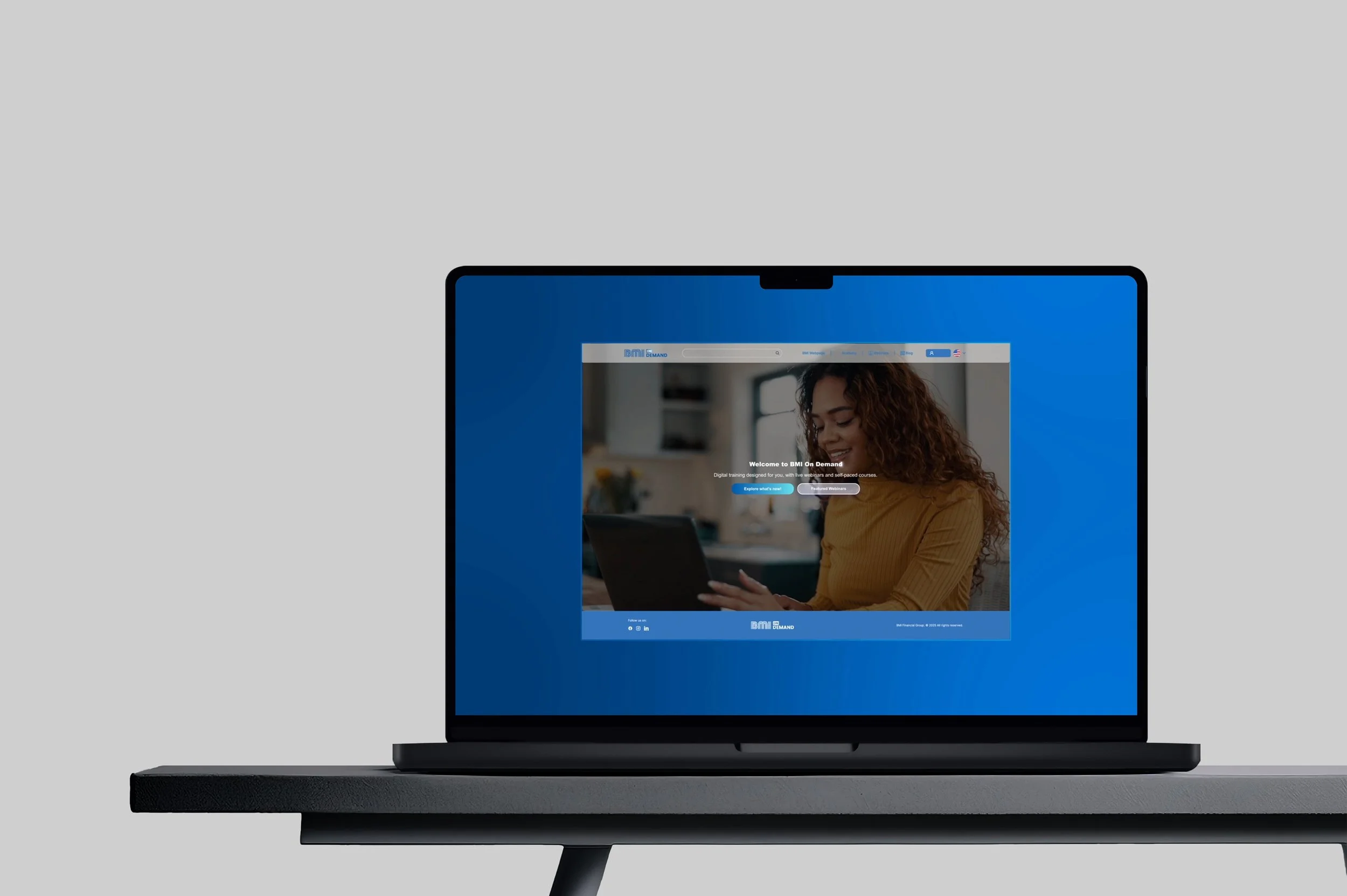 Pantalla de computadora portátil con página web de BMı en demanda y una mujer sonriendo con un dispositivo táctil en un ambiente interior.