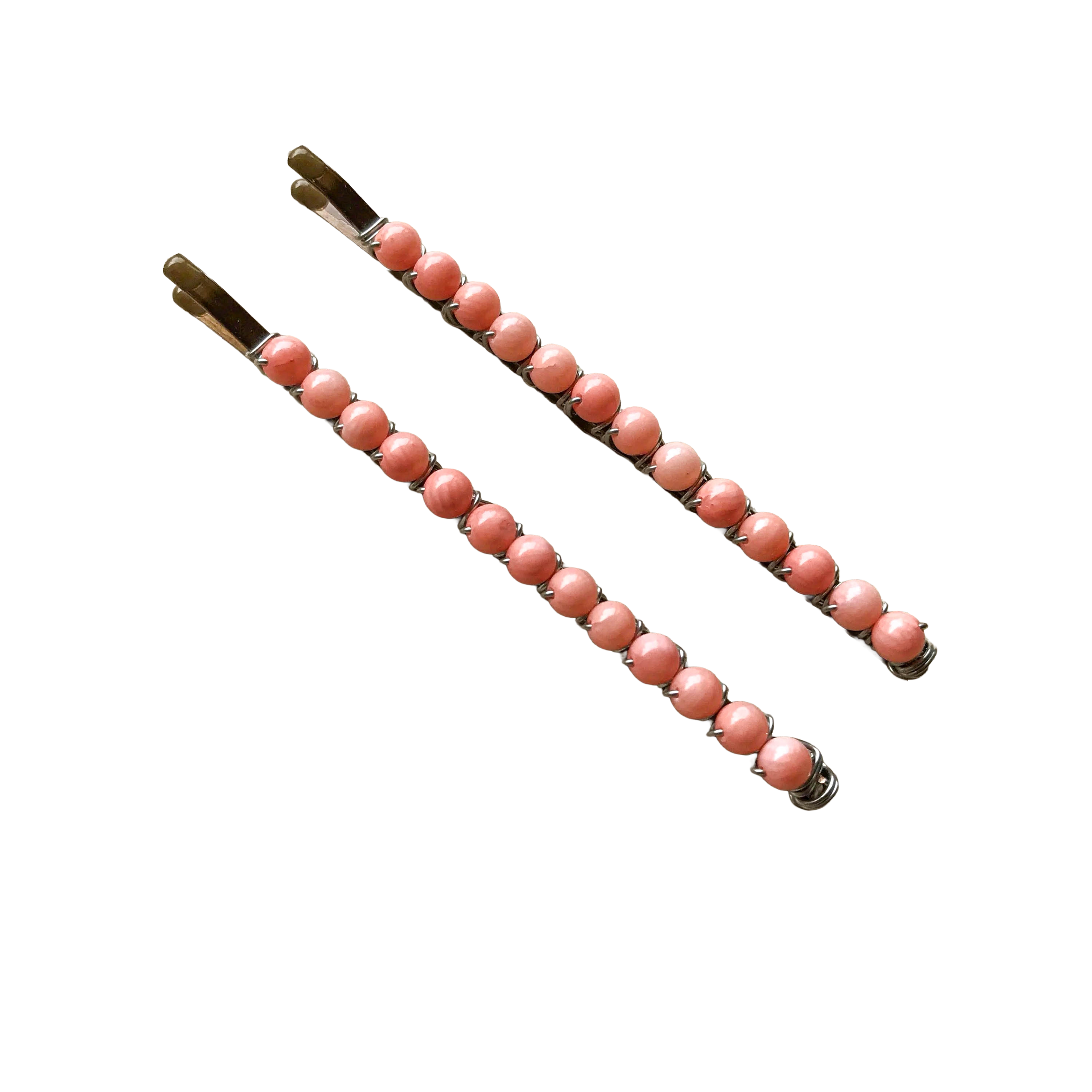 Close-up of large black bobby pins wire wrapped with pink round beads.