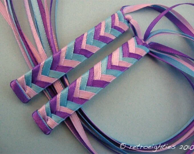 1980s-inspired braided ribbon barrettes with pink, purple, and blue ribbons.