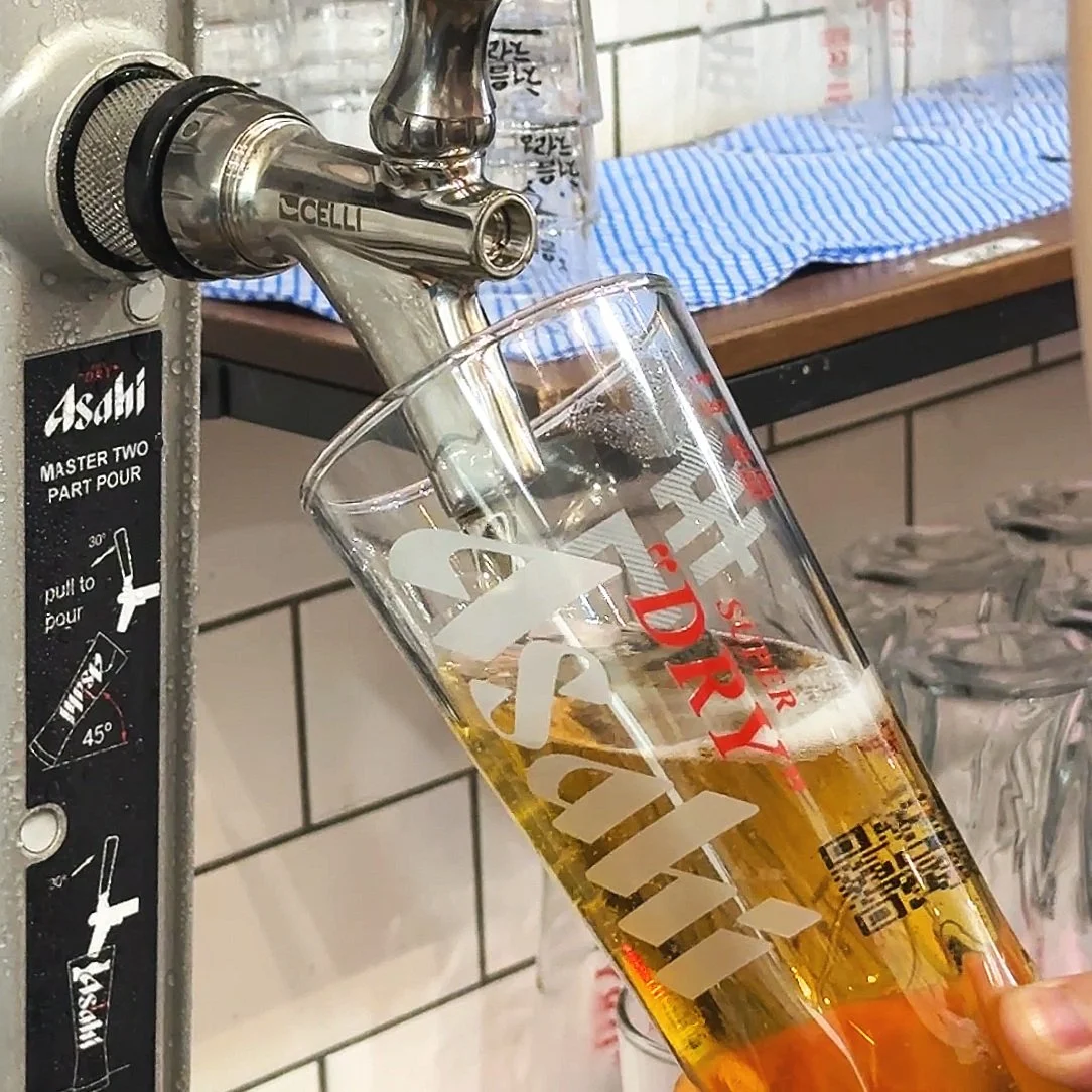Beer being poured from a tap into a glass at a bar or pub.