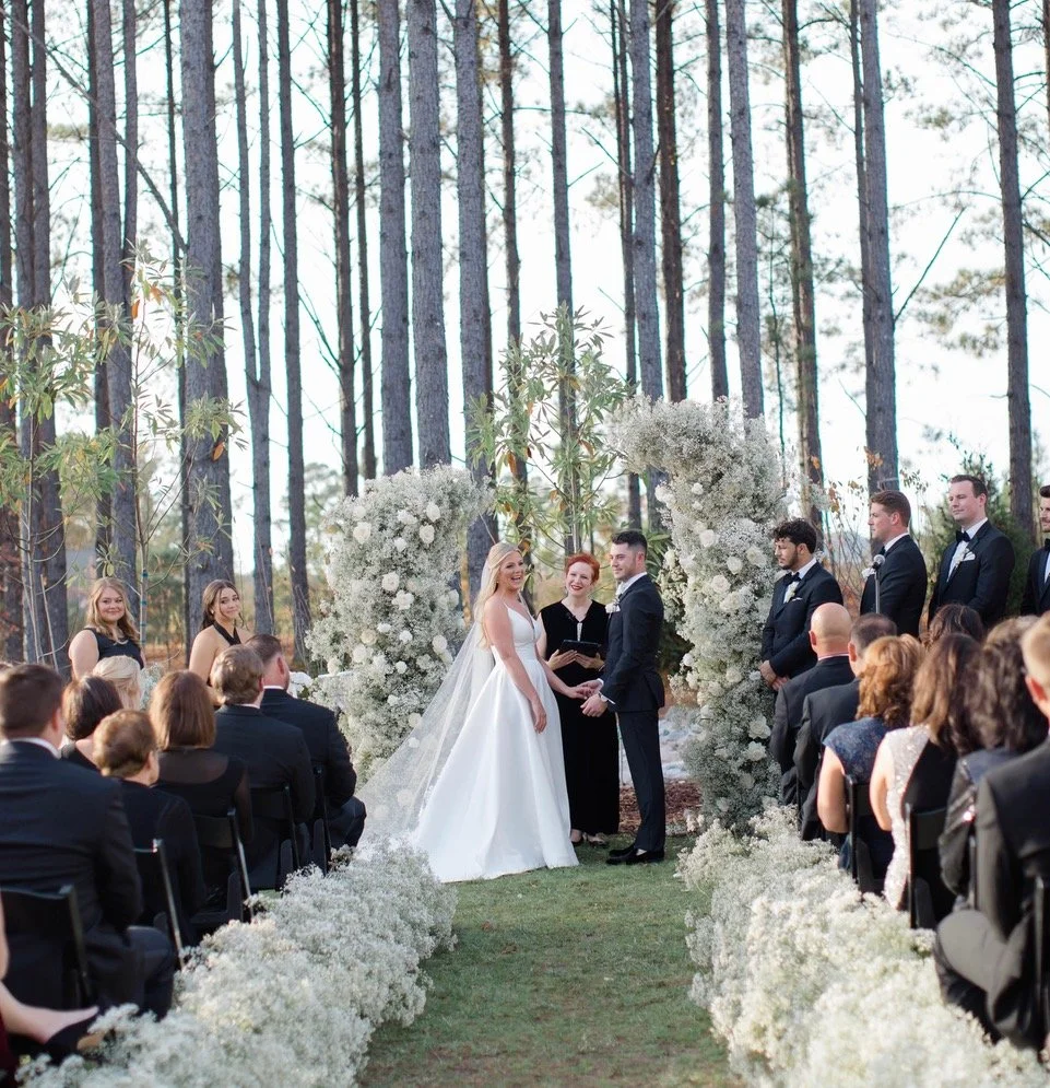Wedding ceremony with officiant, bride and groom and guests at historic estate venue