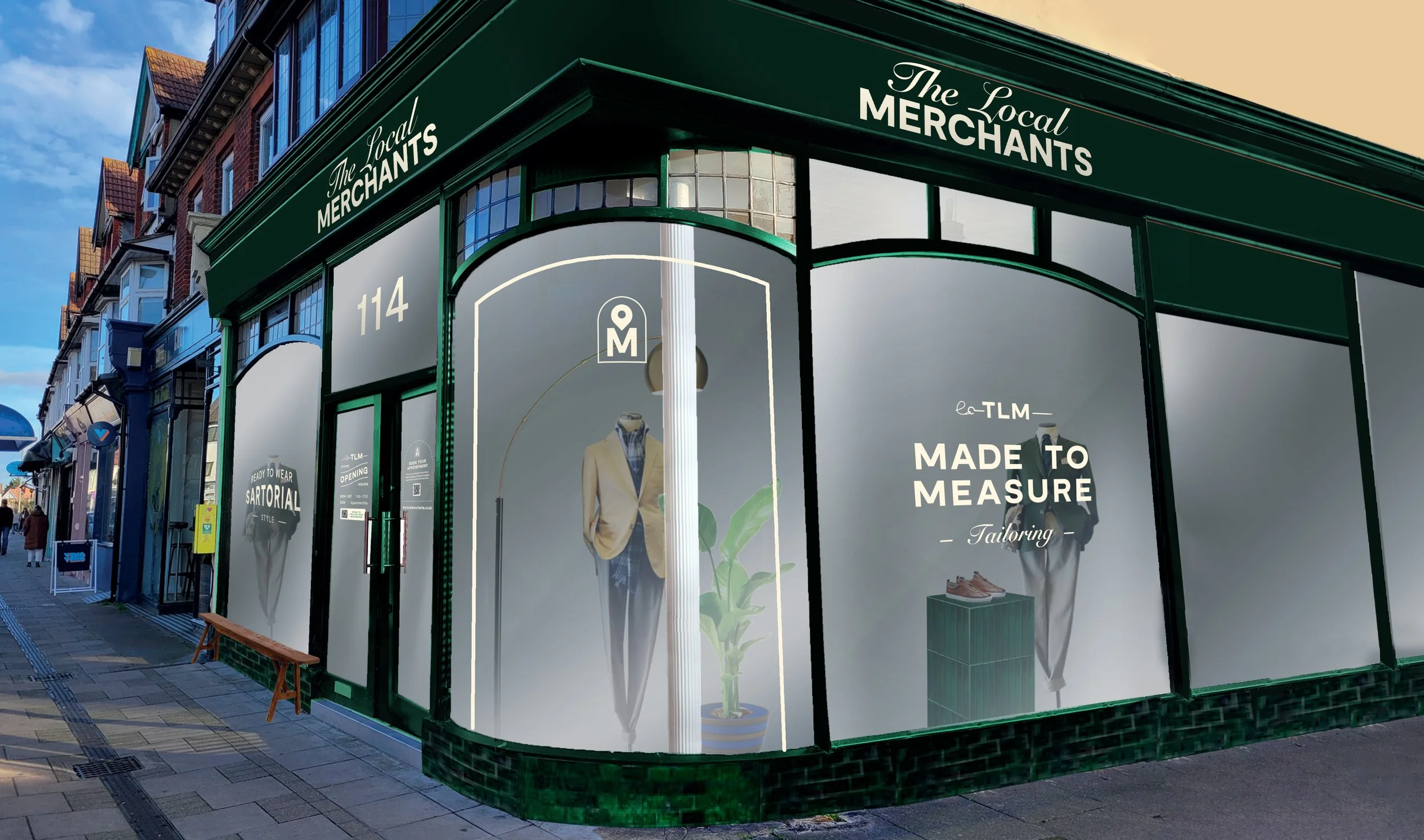 Exterior of "The Local Merchants" storefront at 114, displaying clothing and tailoring services with mannequins and signs for "Made to Measure" tailoring.