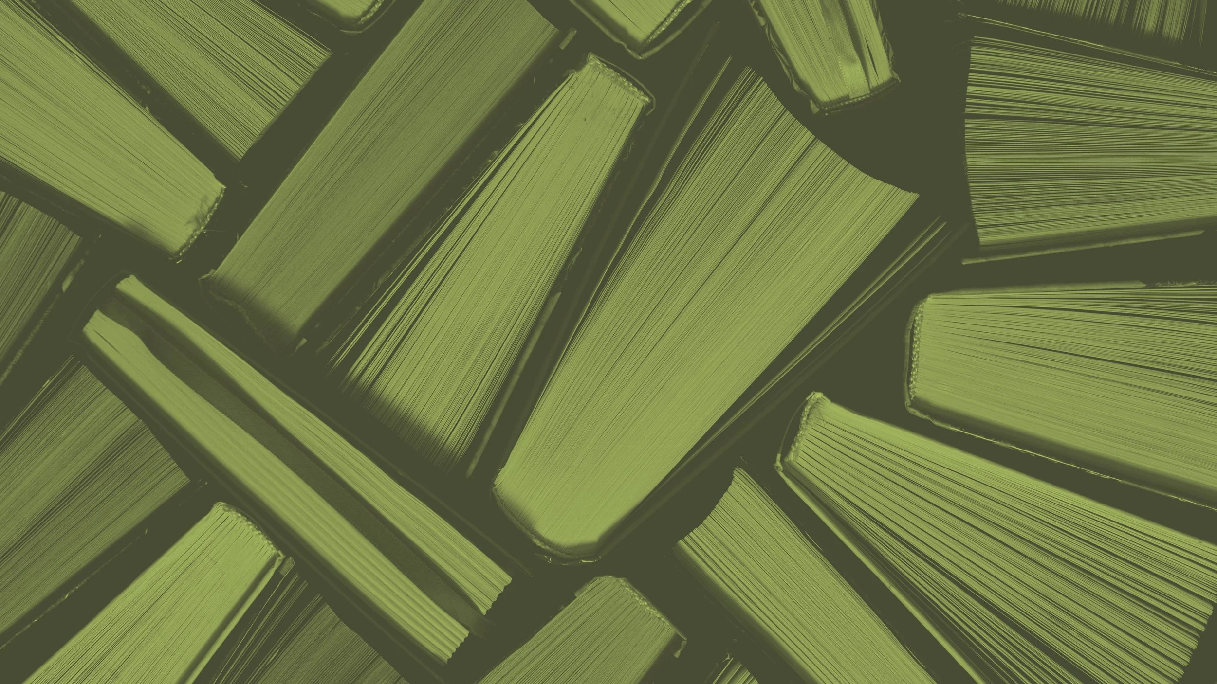 Close-up of multiple greenish-yellow books stacked on a shelf, viewed from above.