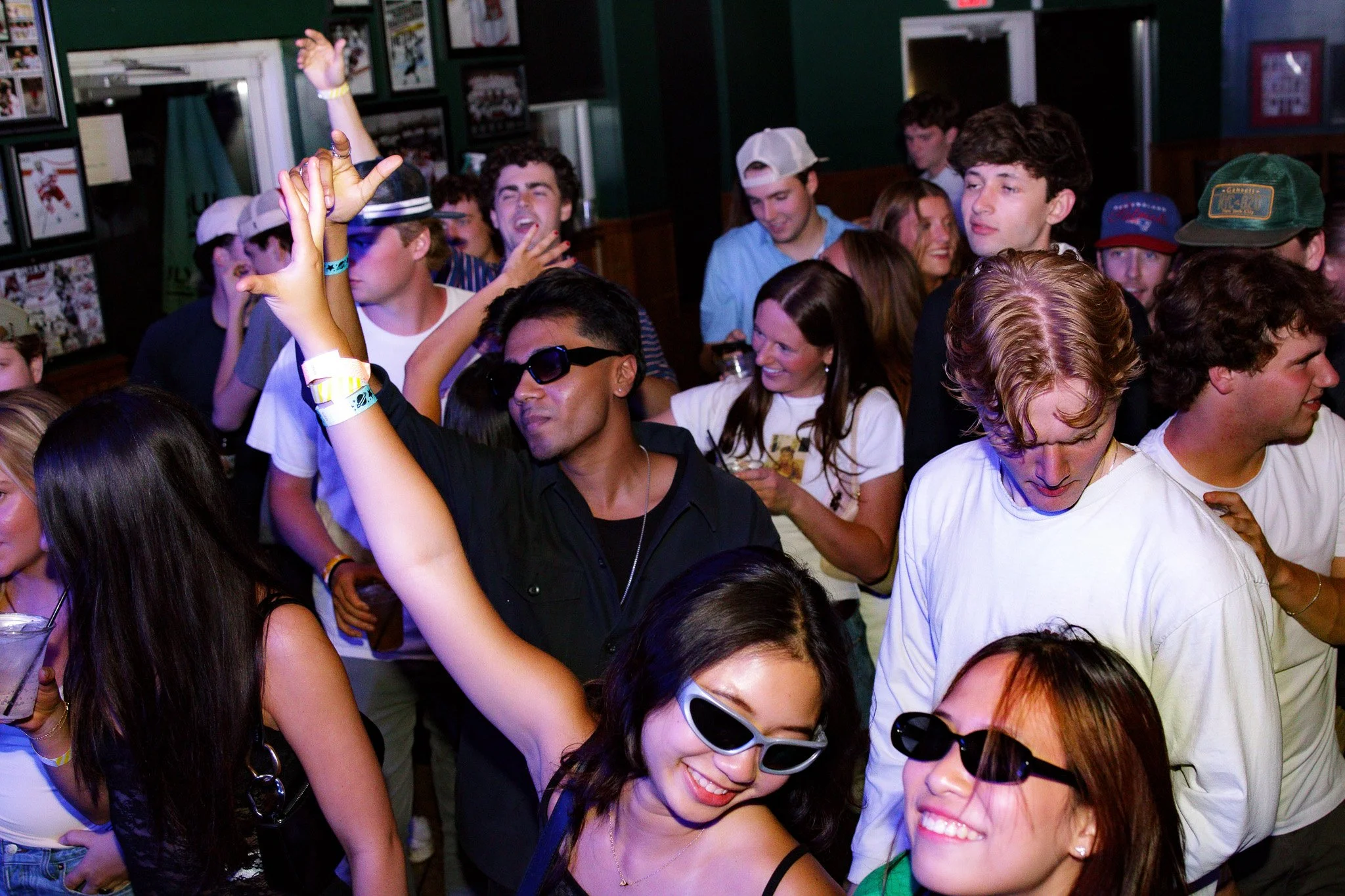 Group of young people dancing and enjoying music at a party or nightclub.