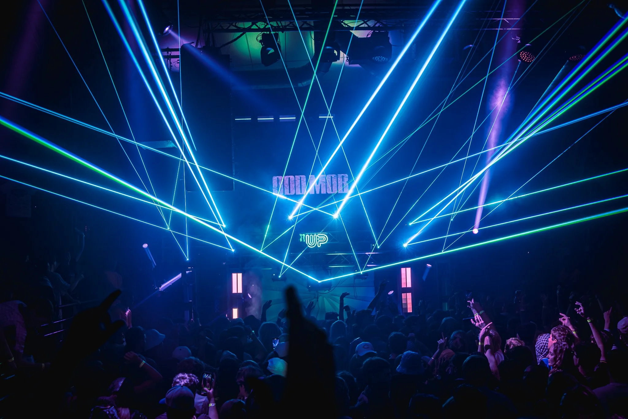 A concert scene with vibrant laser lights and a cheering crowd.