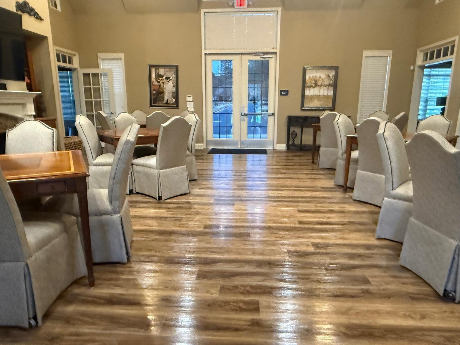 Clean HOA clubhouse common area with tables, seating, and large windows