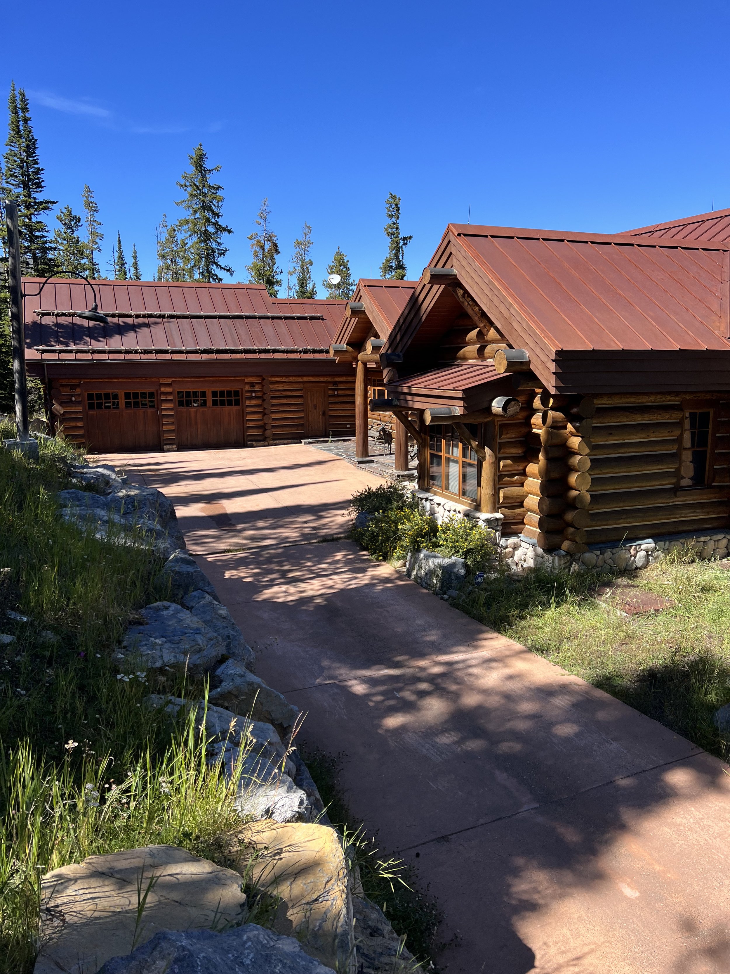 Log cabin with red roof and trees