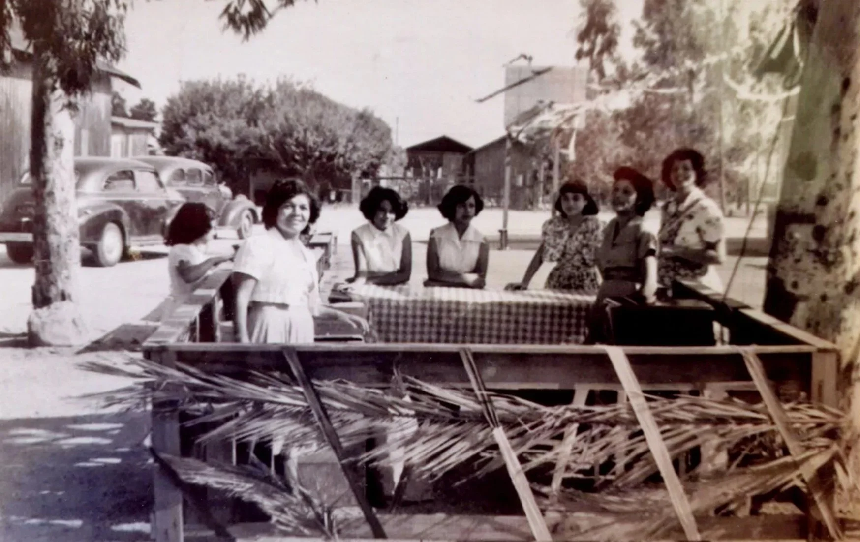 Corinne's mother, Mary Palos (far left), stands with Josephine Molina (second from right), Teresa Montenegro (far right), and others running a jamaica booth in front of Sacred Heart Catholic Church in 1950. (From the Corinne Dearborn Archival Collect
