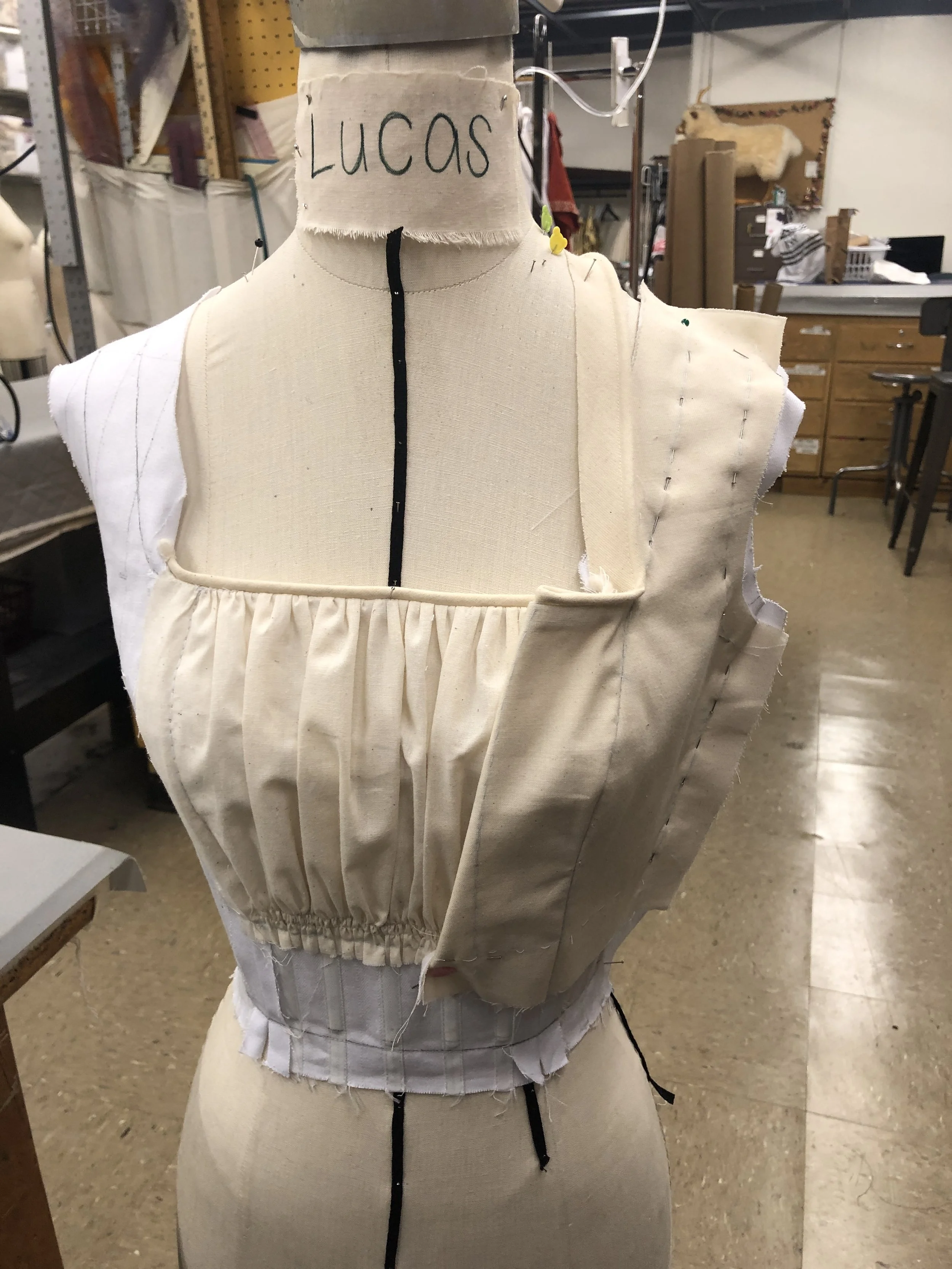Faux chemise piece is attached, and side-front bodice pieces attach and get piped together with the other layers
