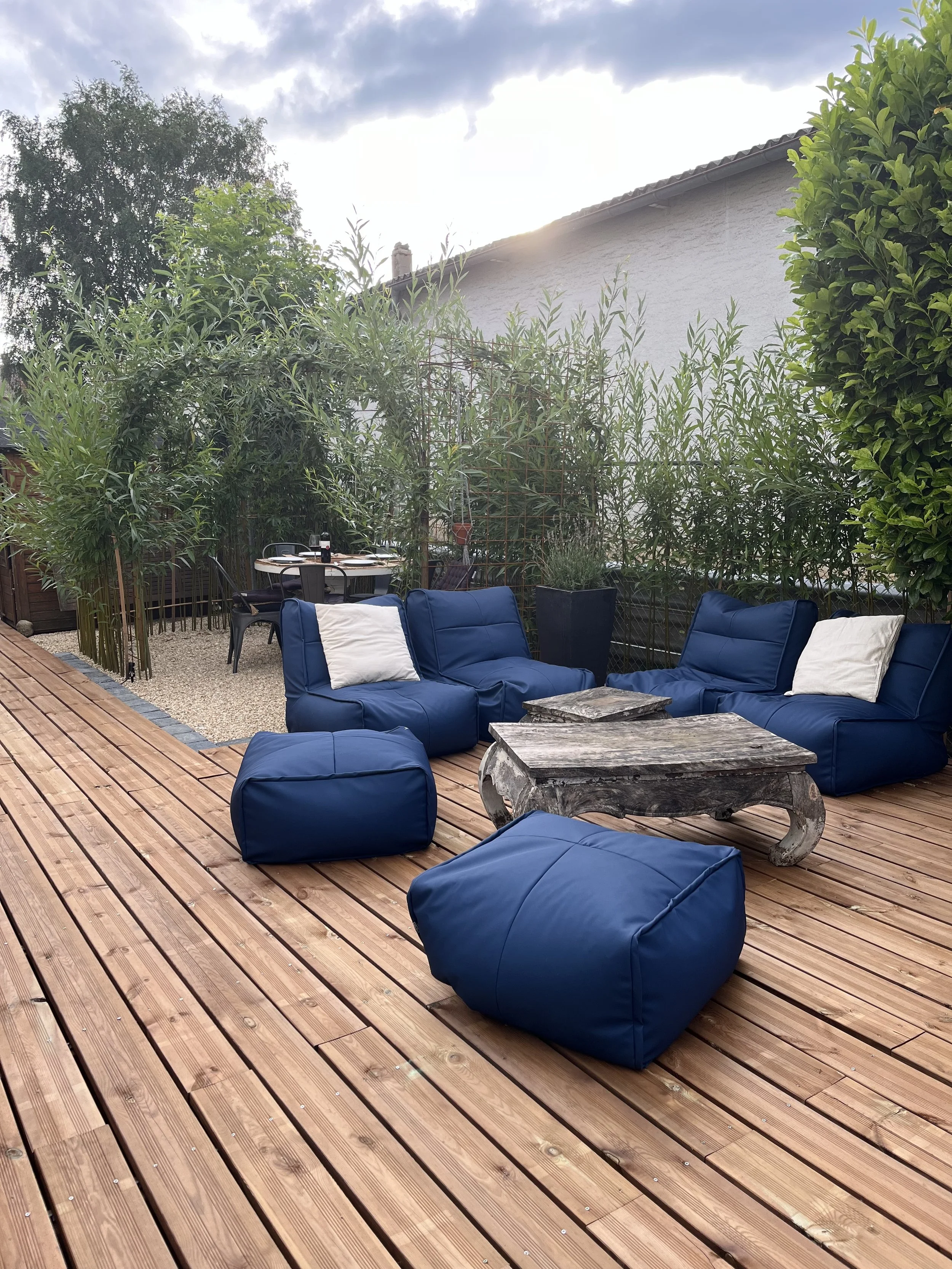 une photo de terrasse en bois et végétation dense.