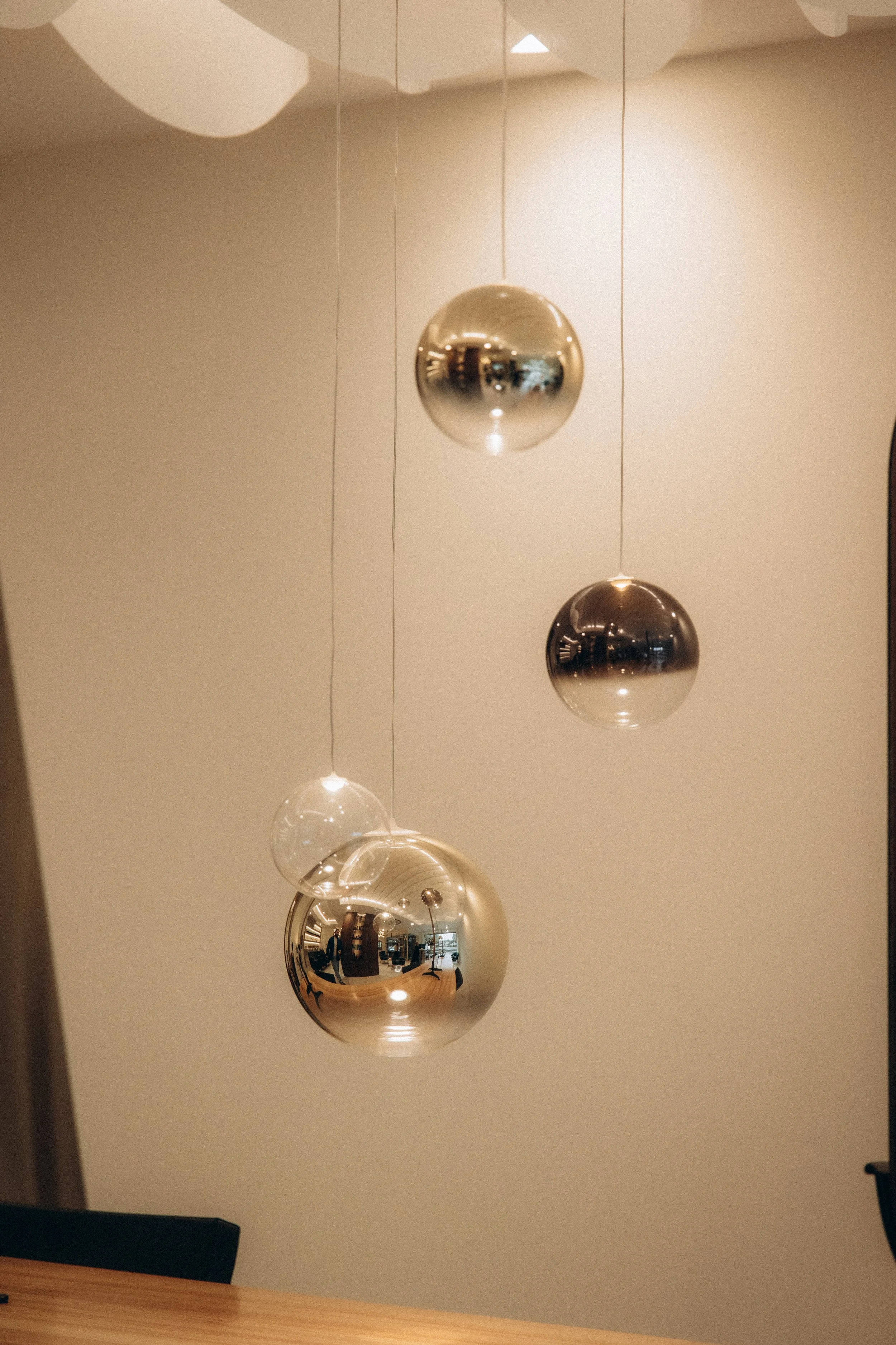 Suspension design avec plusieurs sphères réfléchissantes en métal suspendues au plafond.