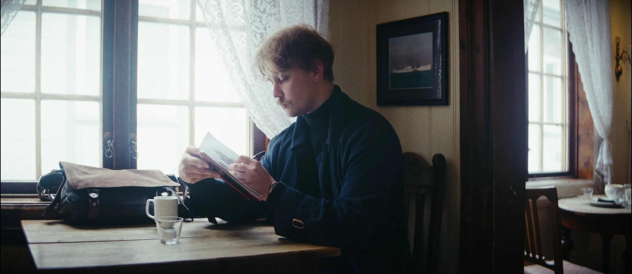 Håvard Poquet, the subject of the NorthHugr documentary Embers, reading in a café.