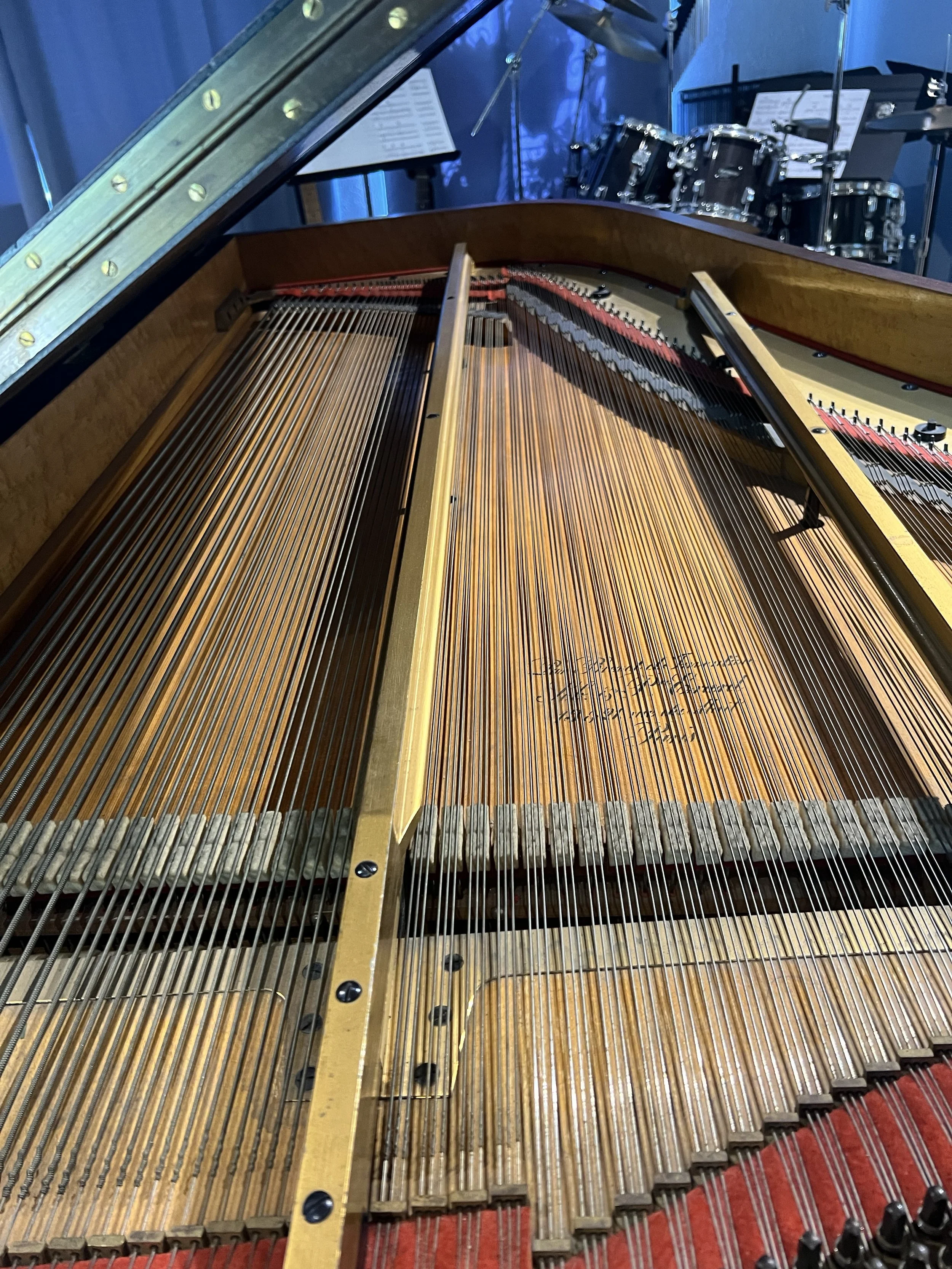 There are a number of things to note in this photo of the Erard. First, you can see that it is straight-strung. Modern pianos are cross-strung to make room for longer strings in shorter cases. Then note that the dampers damp the strings from below