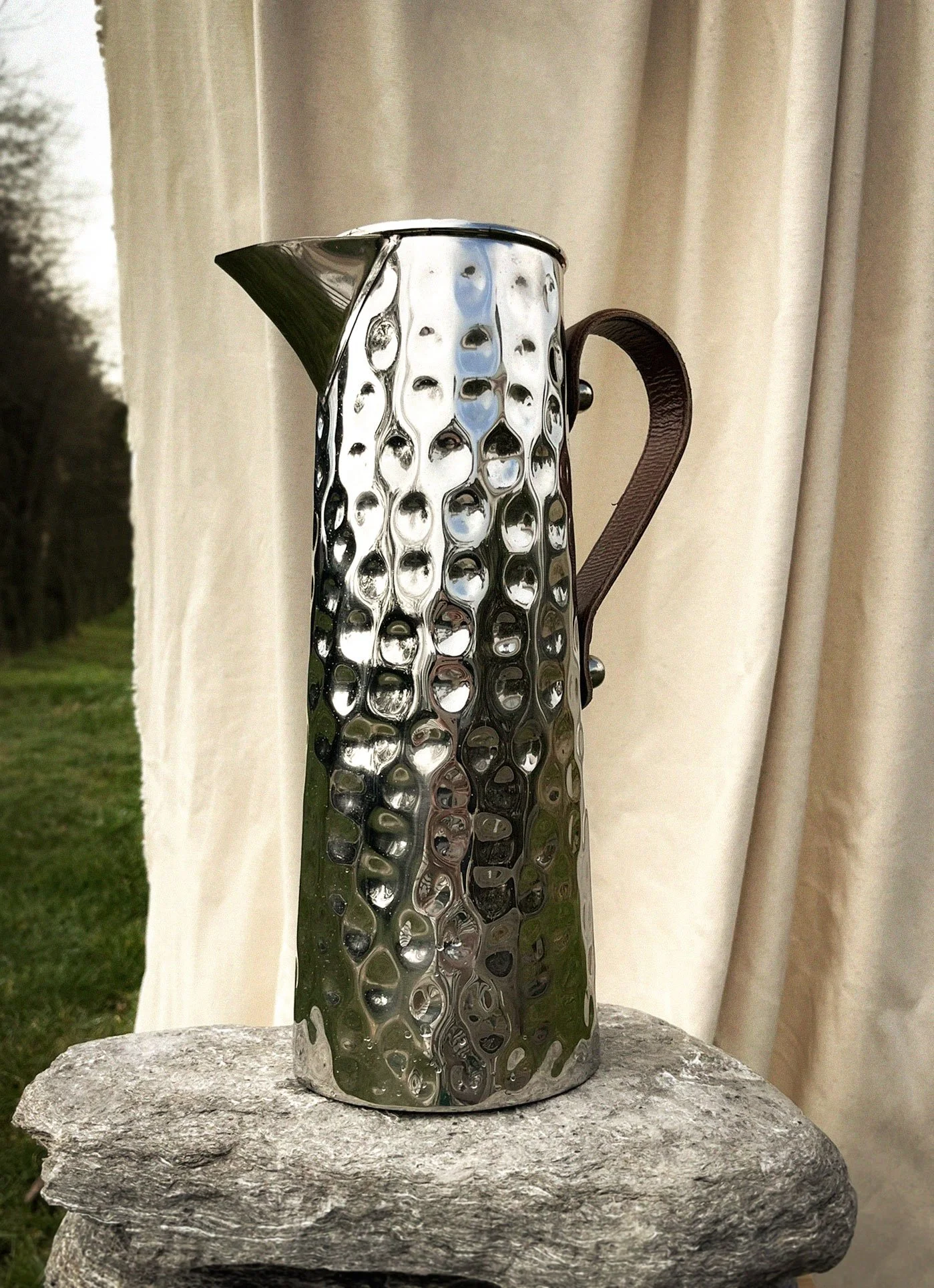 Metal hammered jug with leather handle