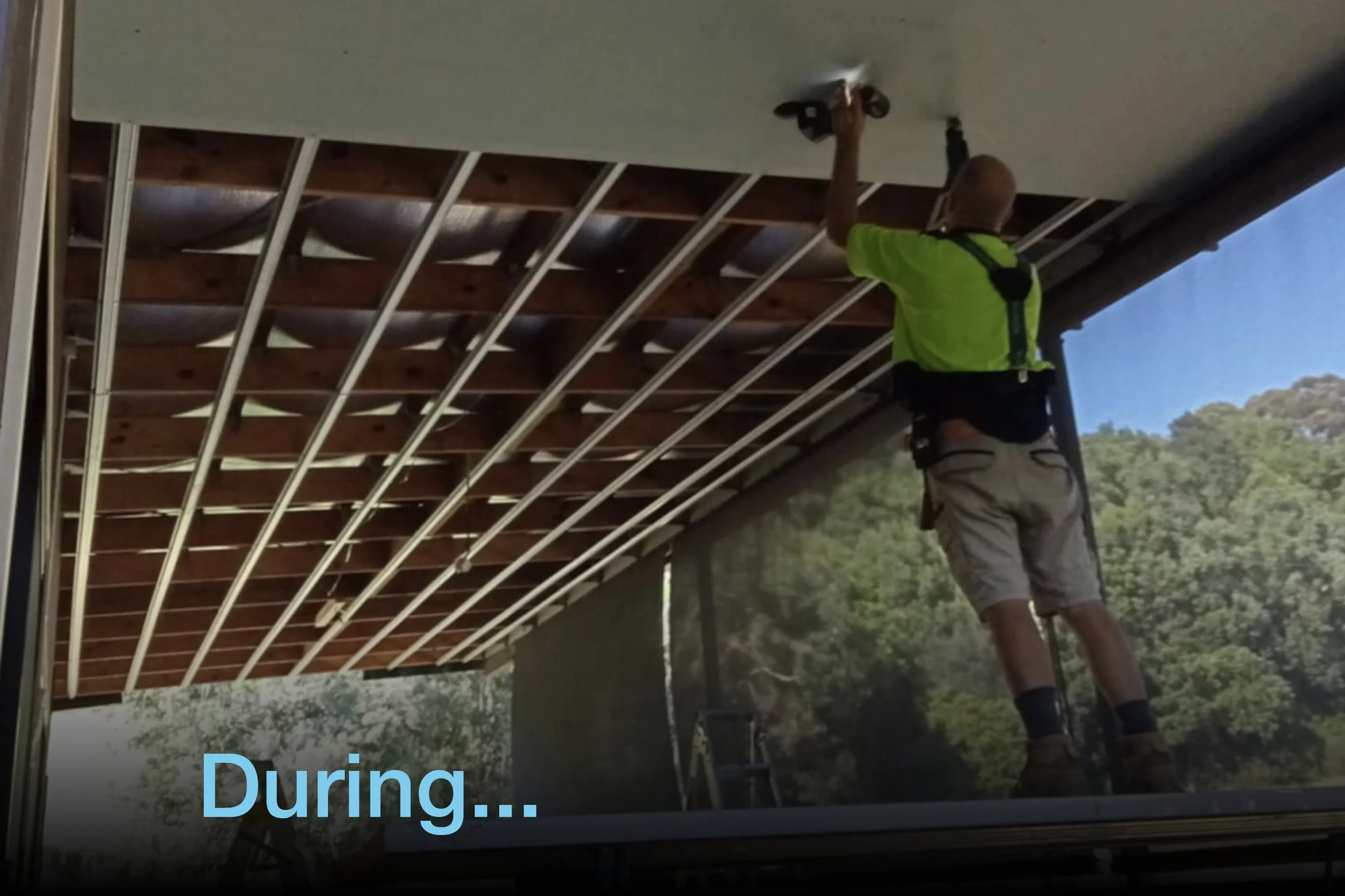 Construction worker installing plastering on a ceiling panel outdoors