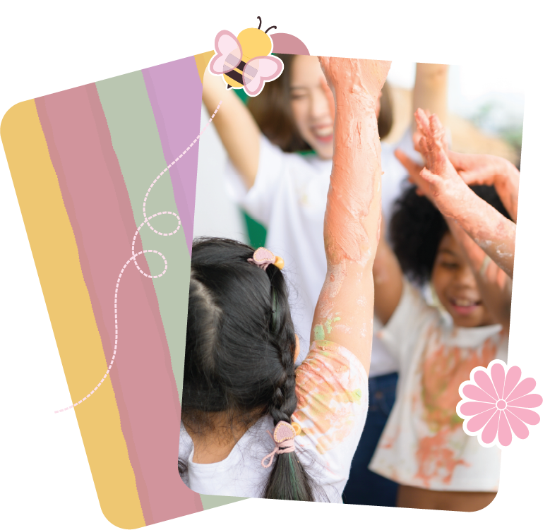 Children in a group therapy session smiling with their arms up, covered in paint and slime.