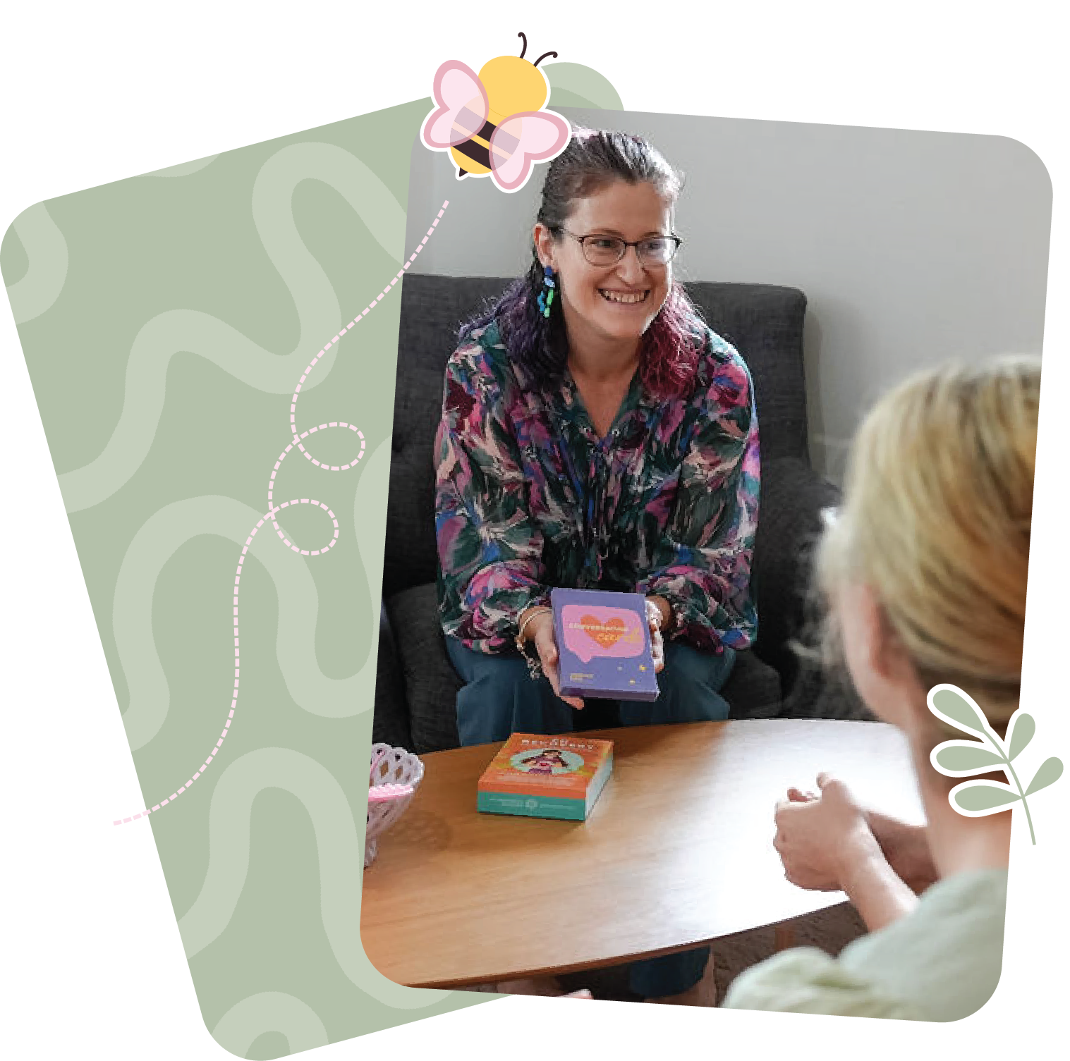 A female clinician, smiling whilst conversing with a parent about neuroaffirming eating support.