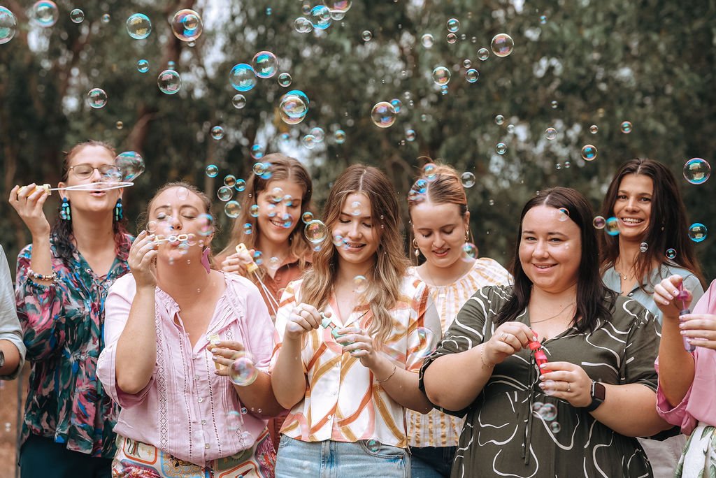 Group of smiling clinicians, blowing bubbles and having fun.