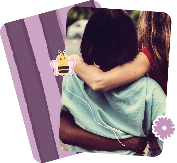 Two people hugging outdoors, one with dark hair and the other with light brown hair, surrounded by cartoon stickers of a bee and a flower on a purple background.
