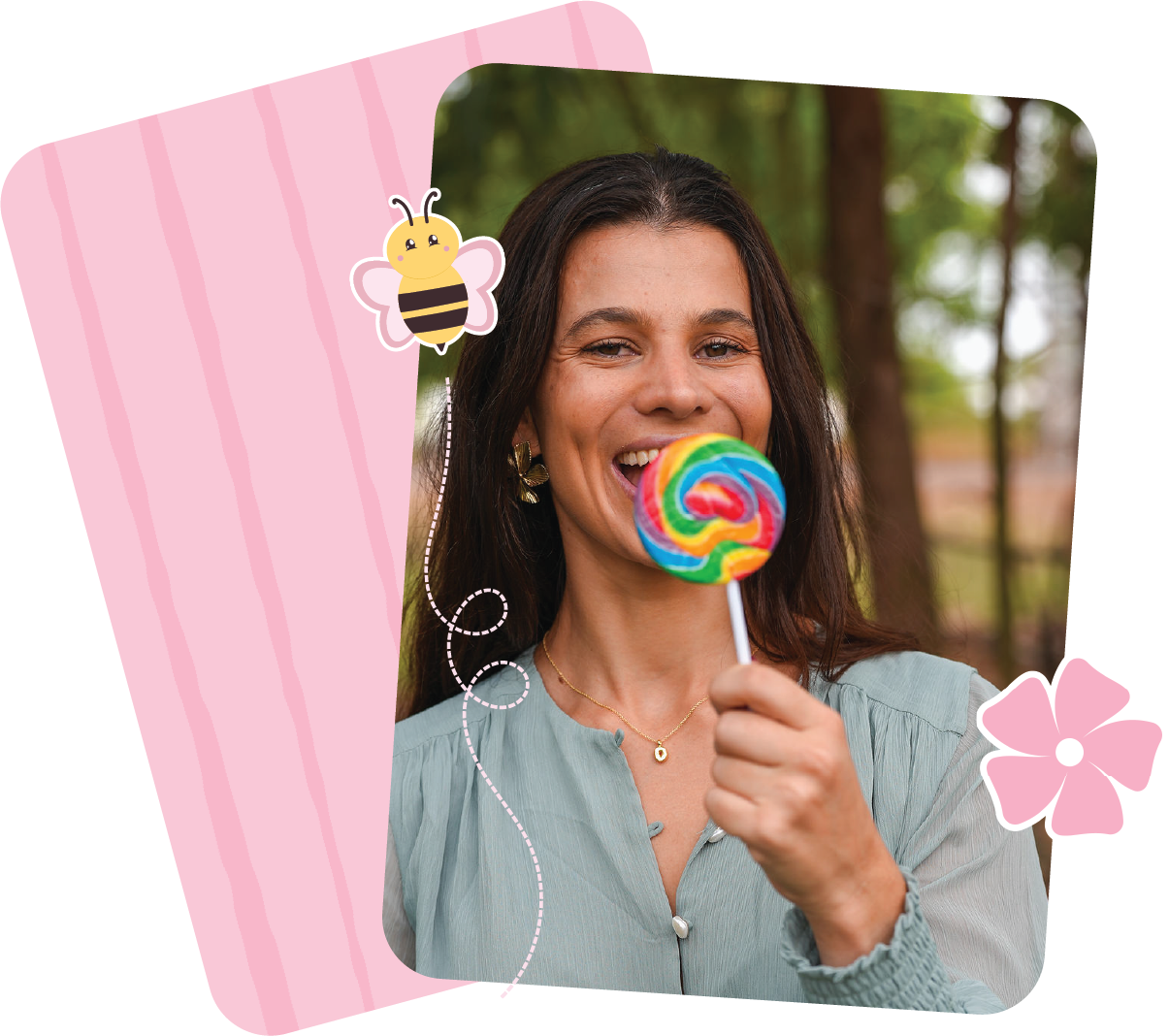 Clinician smiling and holding a rainbow-coloured lollipop outdoors.