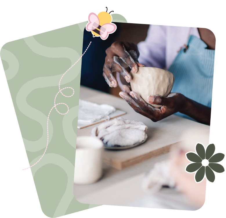 Person shaping clay with hands in a pottery class.