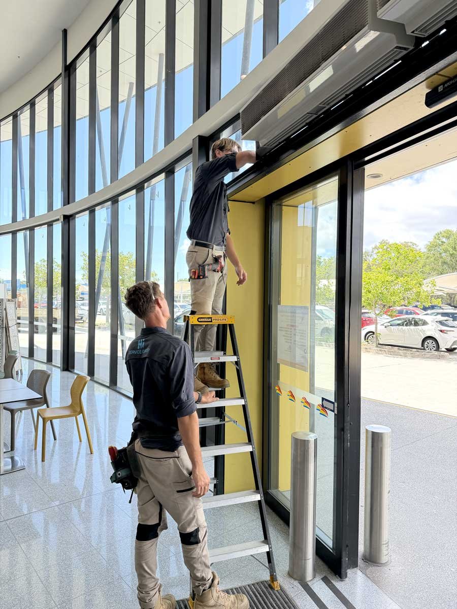 2 men fixing automatic opening doors