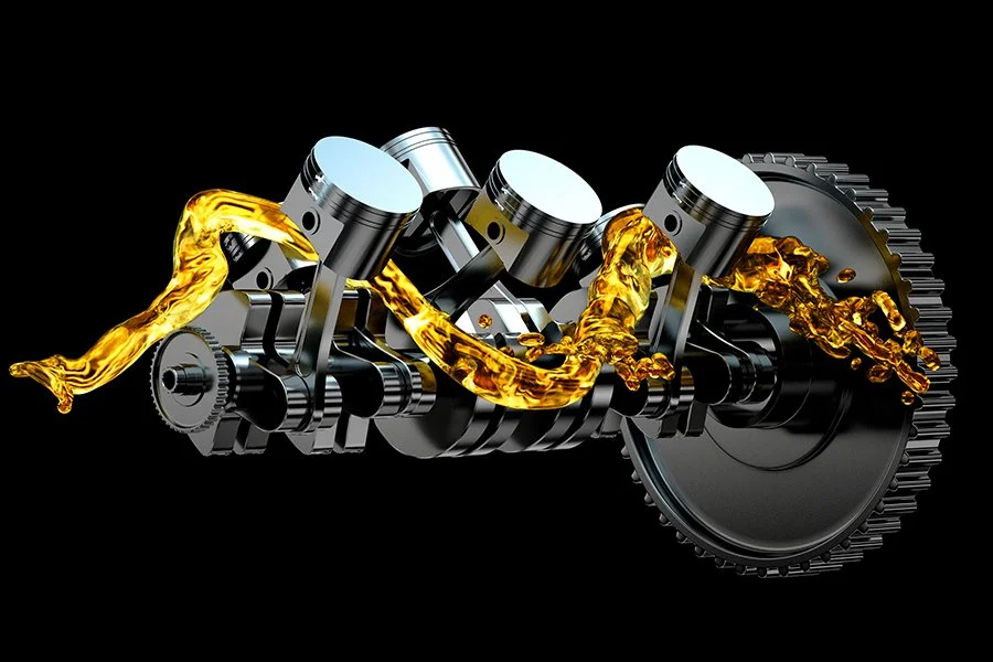 A mechanical engine with pistons and gears, with oil flowing through it, isolated on black background.