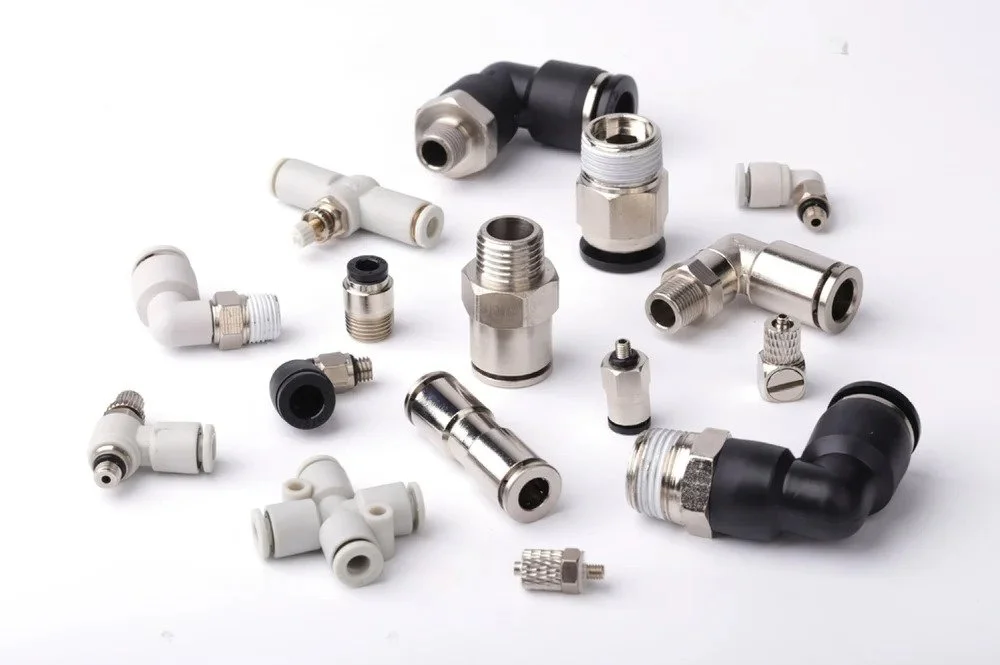 Various metal and plastic fittings, connectors, and elbows for plumbing or pneumatic systems on a white background.