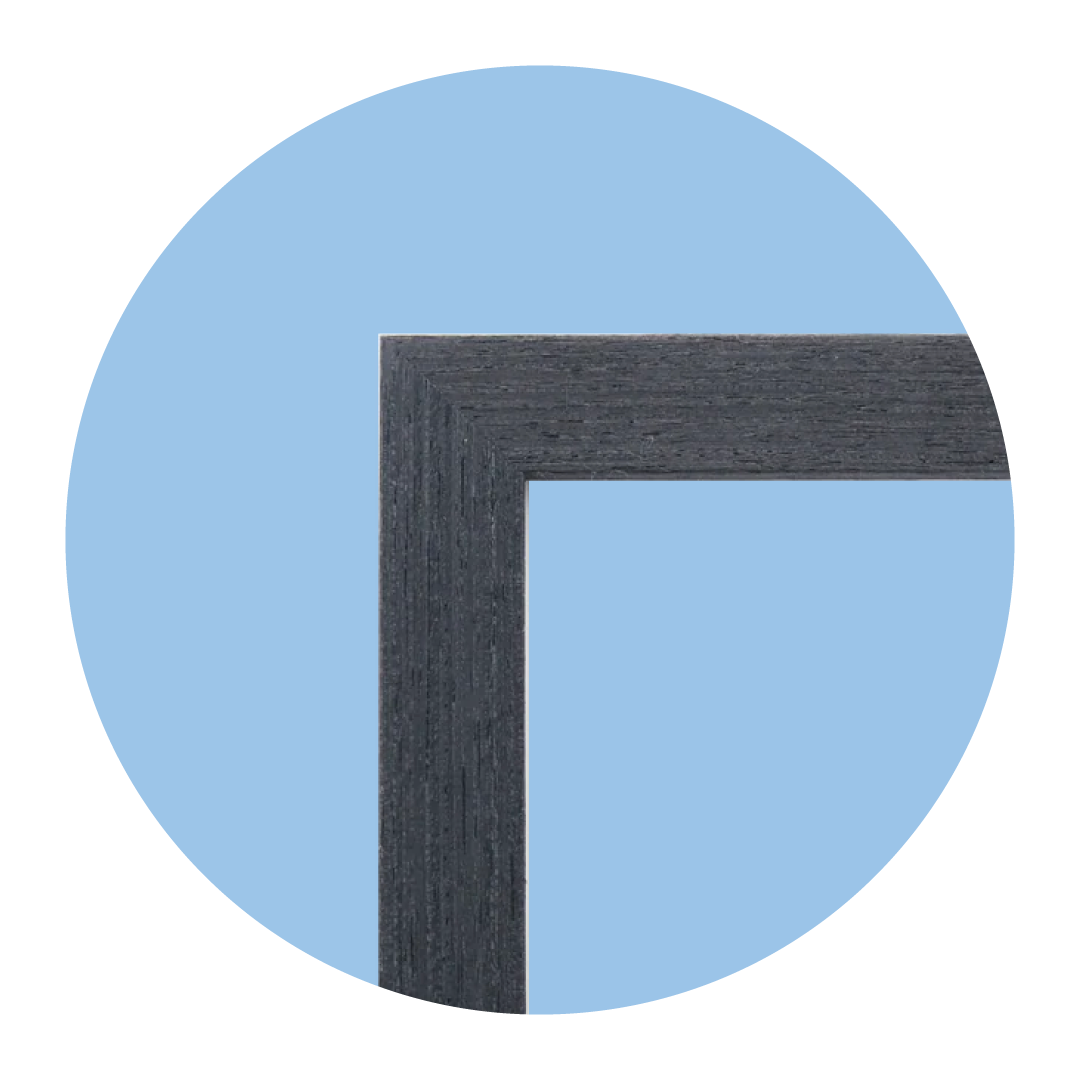 Close-up of a corner of a dark wood picture frame against a blue background.