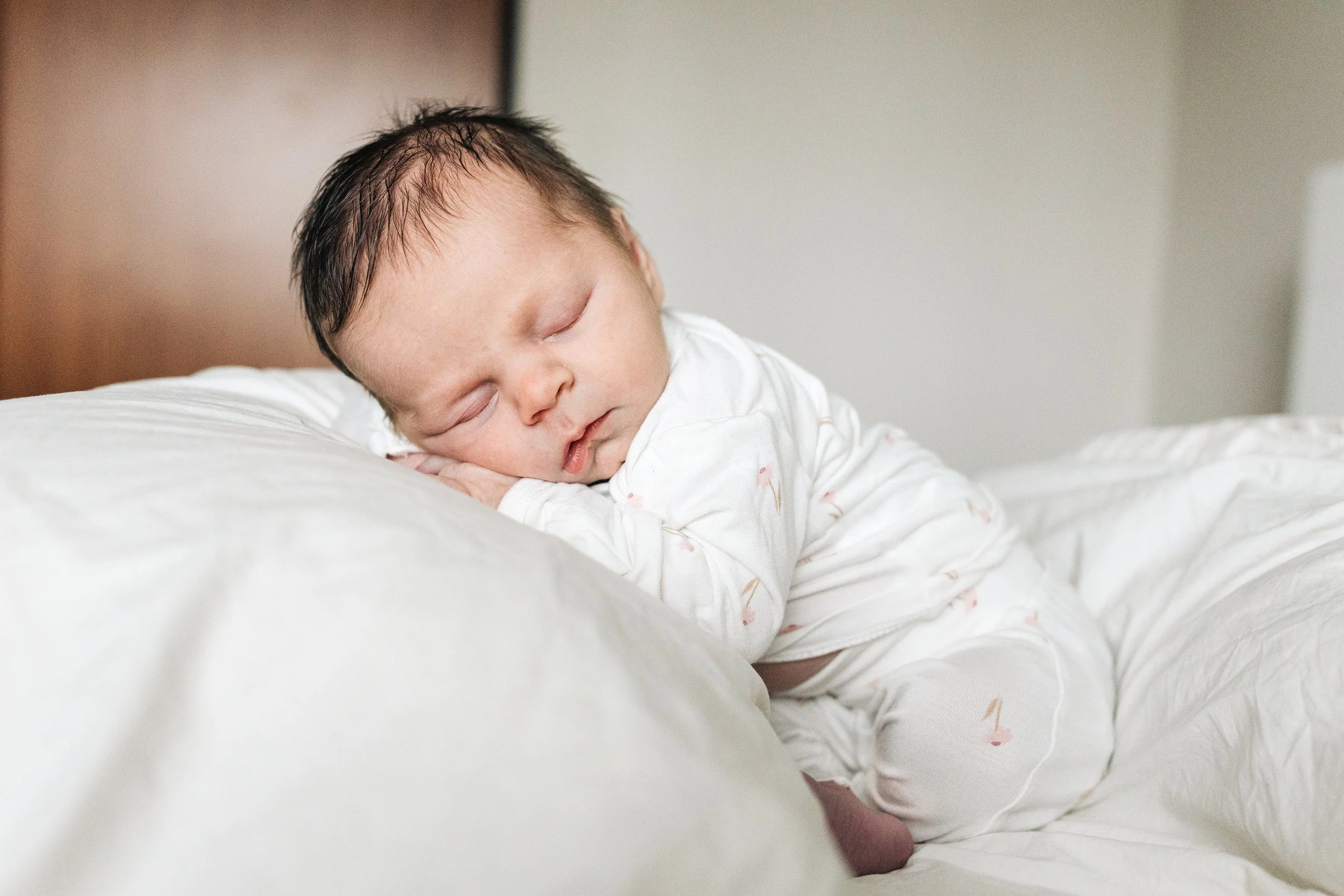Mexican family holding their newborn son in a well lit living room.