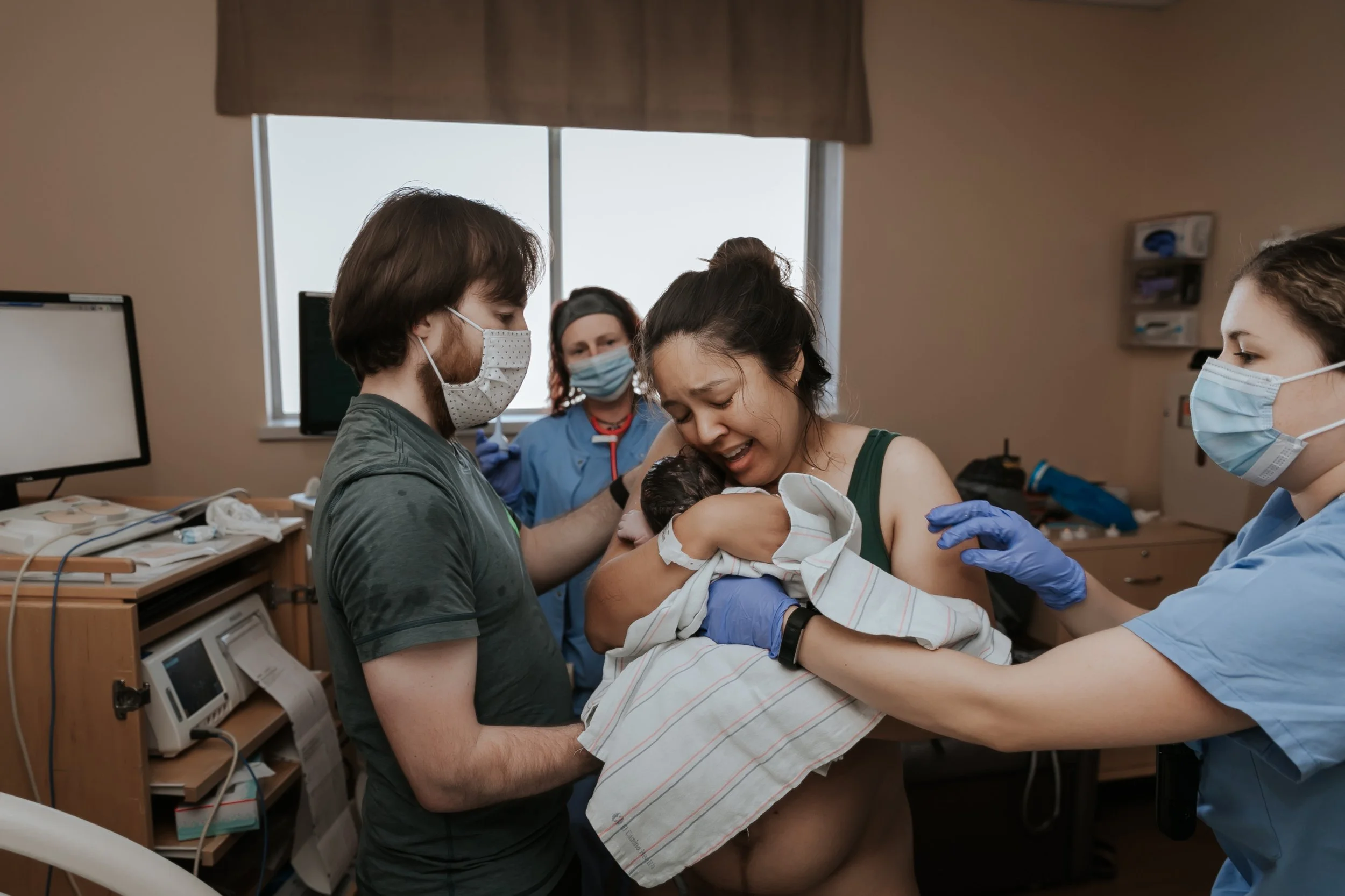 Mom greeting baby after birth. Photo taken by Bay Area Birth Photographer Paige Driscoll.