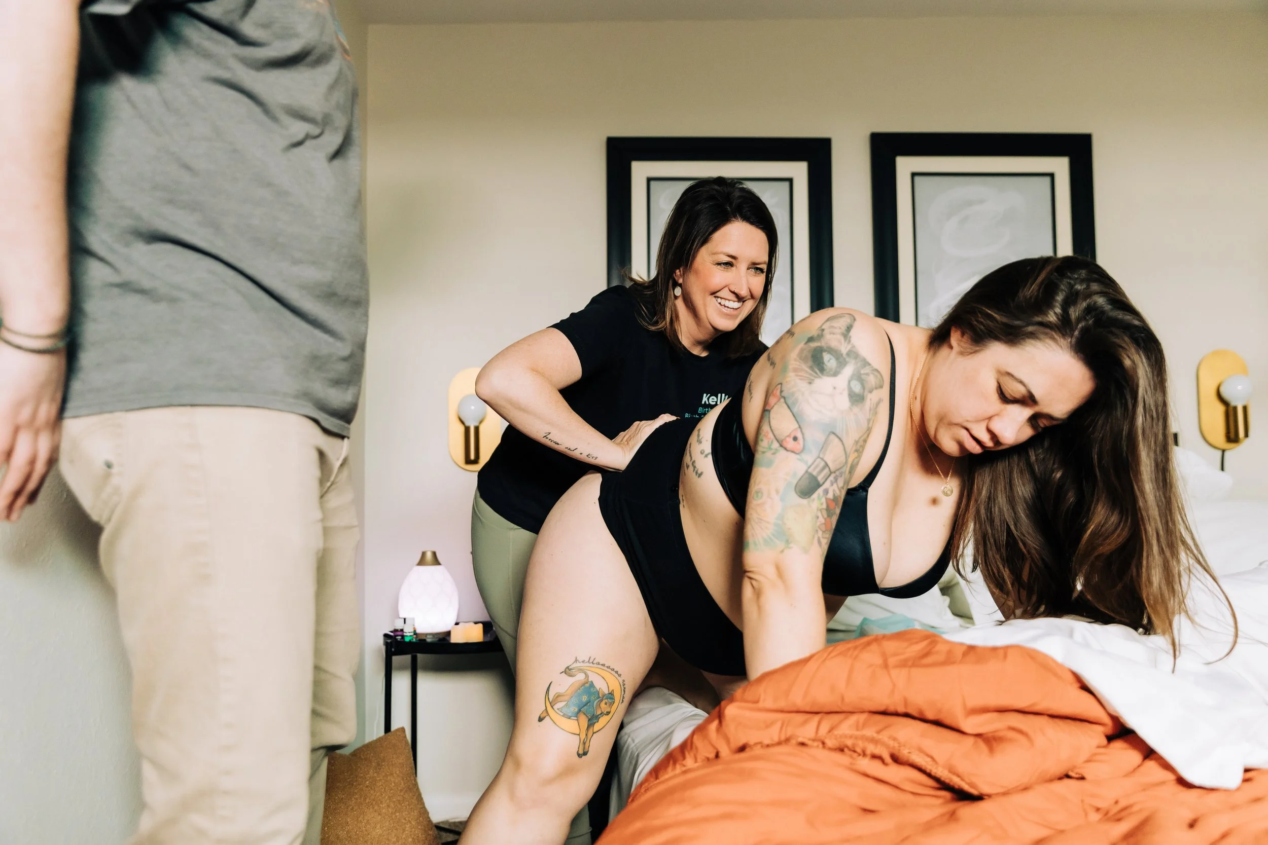 Pregnant mom laboring at home with doula doing hip squeezes