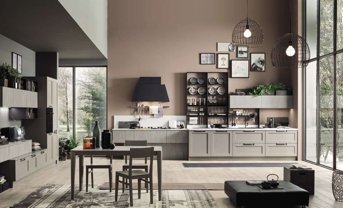 Modern kitchen with beige cabinets, black accents, and large glass windows with outdoor view.
