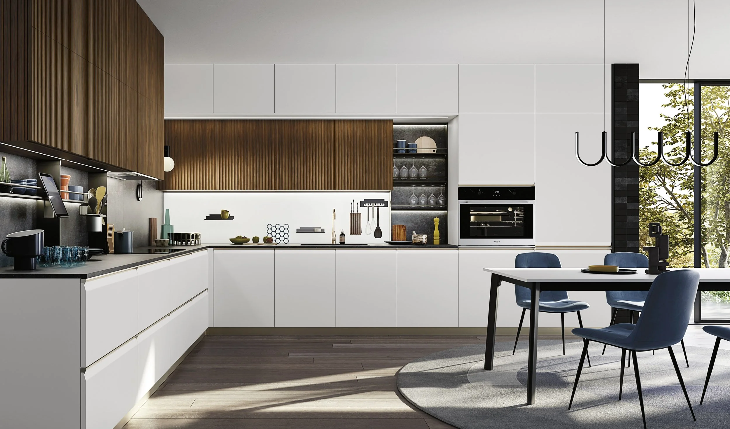 Modern kitchen with white cabinets, wooden upper cabinets, black countertops, and a dining table with blue chairs, next to large windows with trees outside.