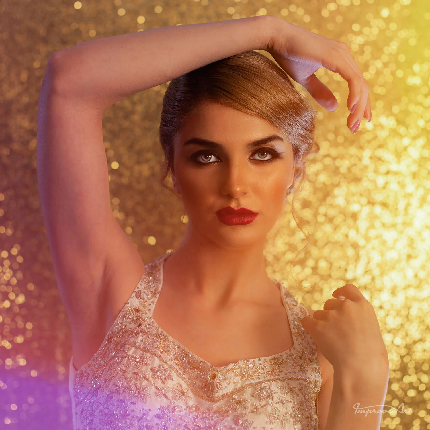 A woman with styled hair, wearing red lipstick and a sleeveless dress, posing with her left arm raised and her right hand clenched into a fist in front of a sparkly gold background.