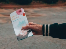 Person holding a book or card outdoors