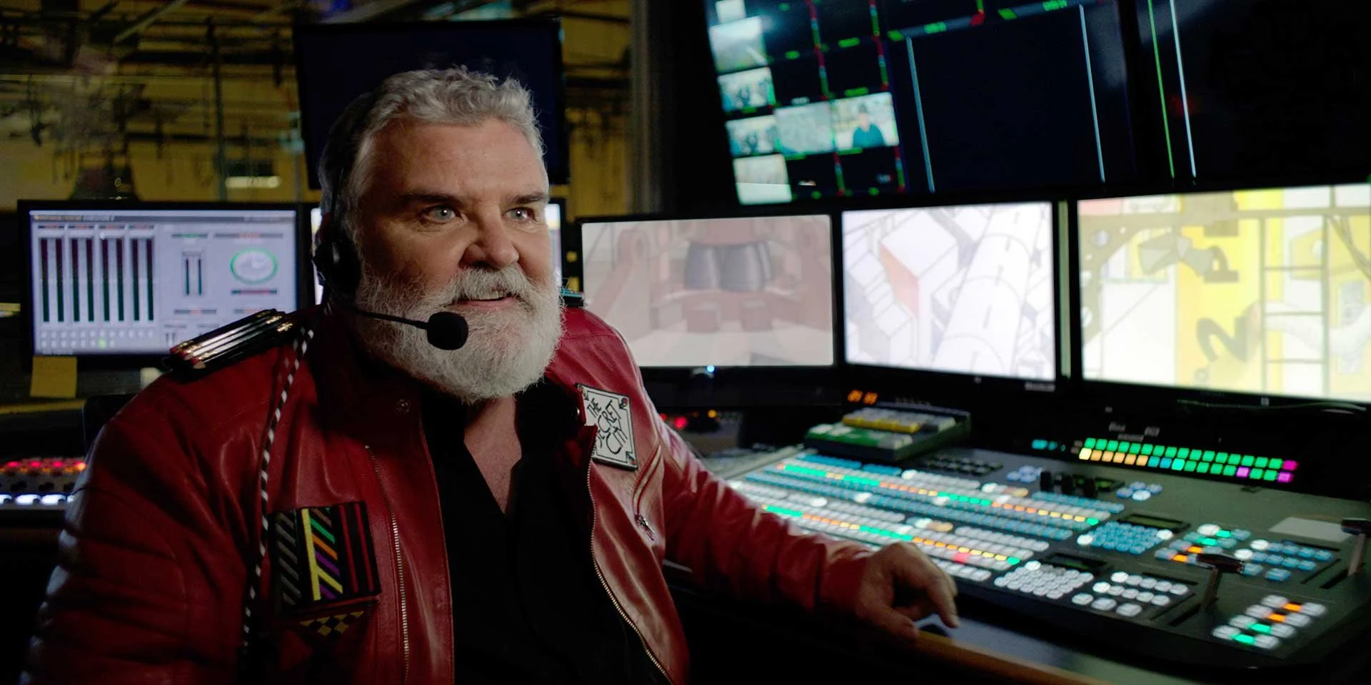 Commander Mark Kistler with a headset sitting in front of multiple computer monitors displaying control panels and video feeds in a control room. Directed by Jason Corgan Brown for Corgan Studio. 