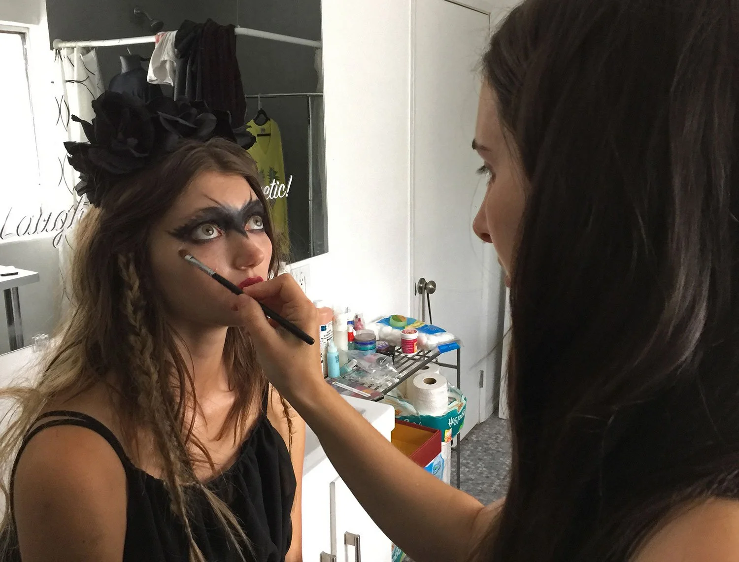 Isabella Brenza is having Halloween makeup applied to her face in a dressing room by Sasha Glasser by Corgan Studio. Directed by Jason Corgan Brown. 