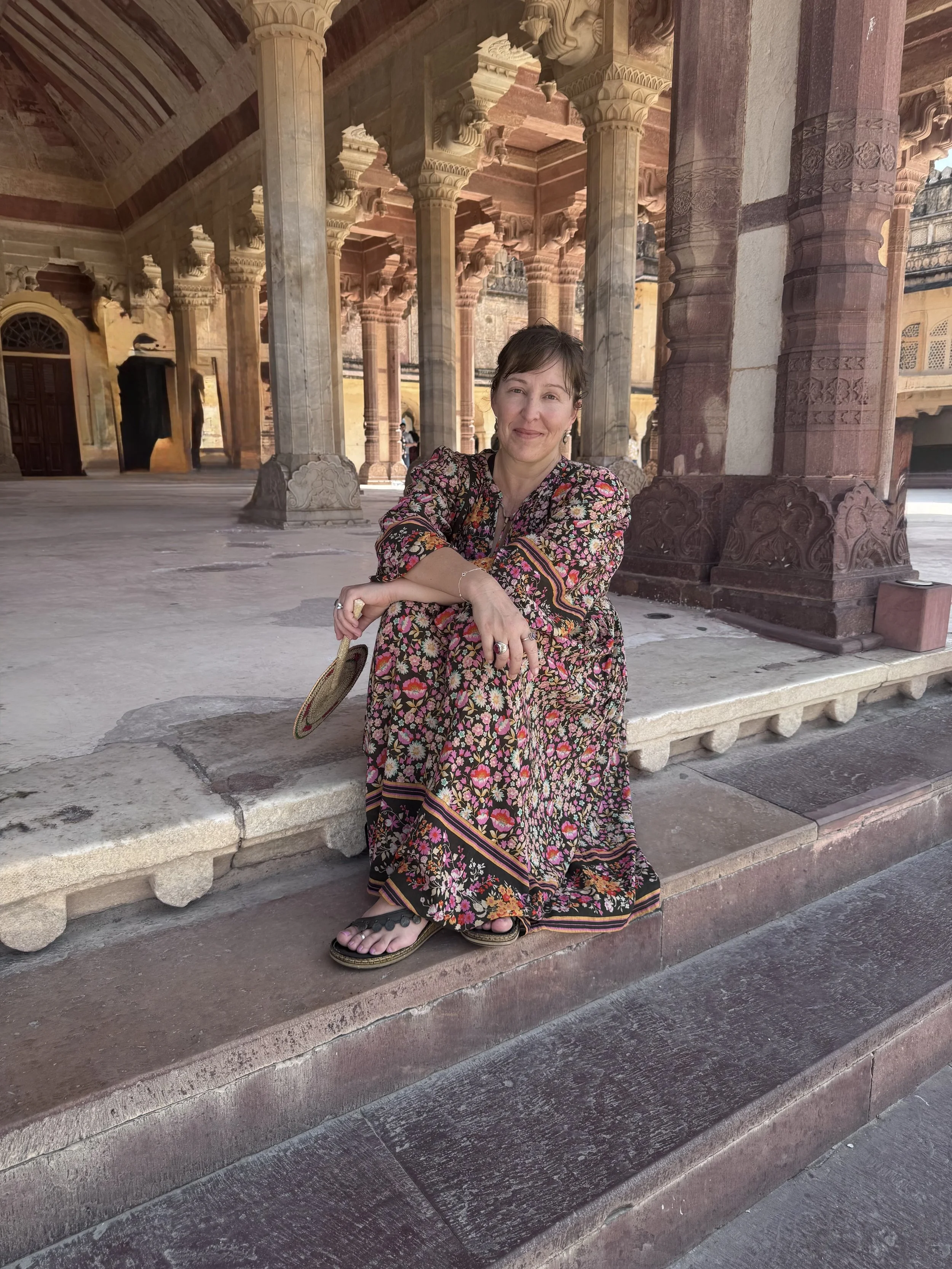 Senior Yoga Teacher with Yoga Australia, Sara Evans is based in Perth and has shared yoga at her bespoke studio, Bloom Yoga since 2012.  Here she is sitting on the steps at the Amber Fort in Rajasthan.