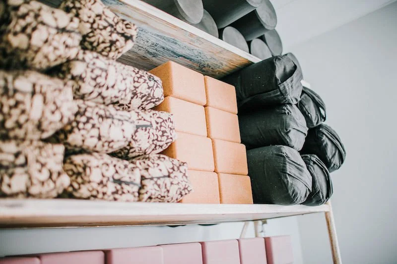 shelf of yoga props including blocks and bolsters in a perth yoga studio