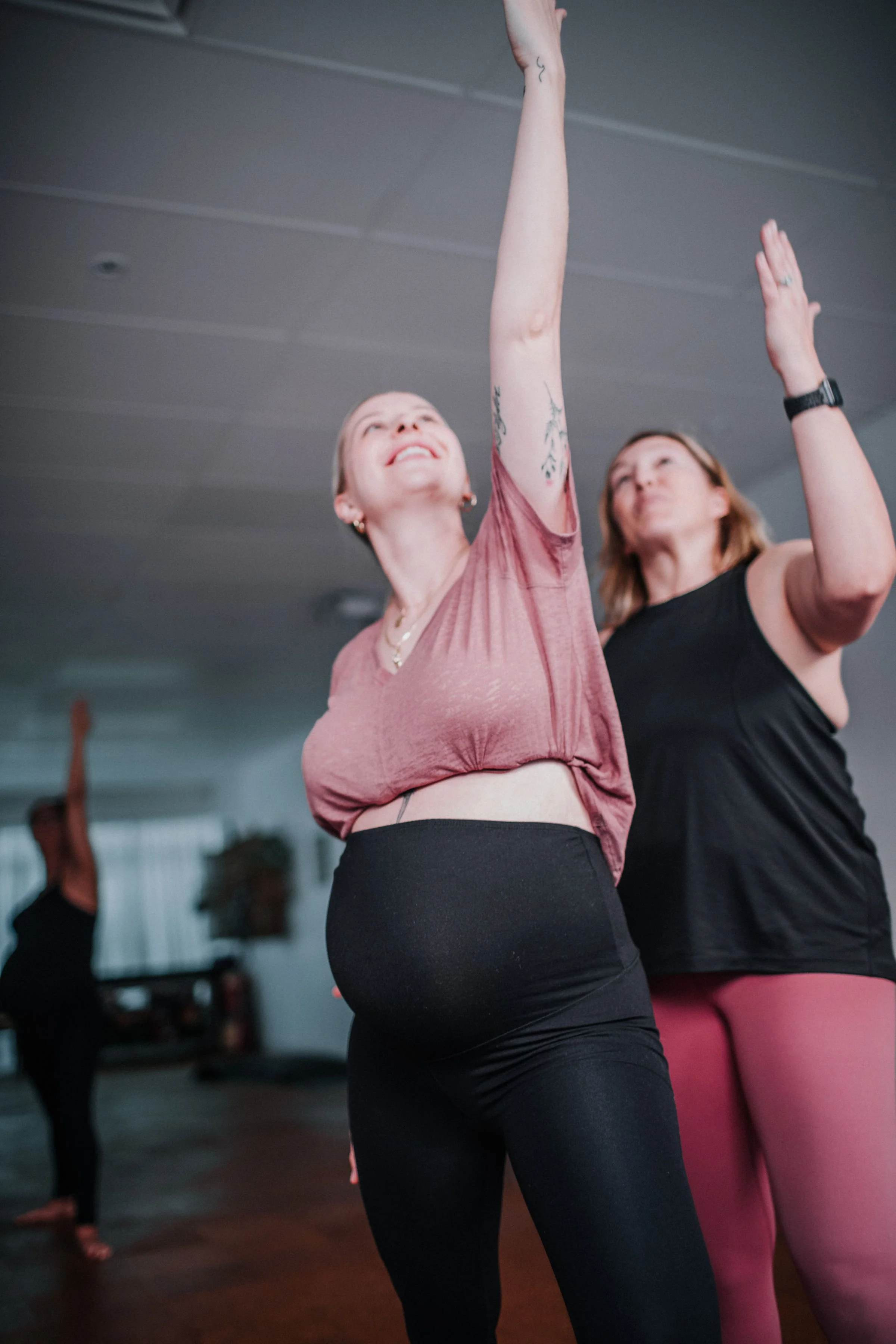 Prenatal yoga teacher assisting a student during a pregnancy yoga class at Bloom Yoga in perth